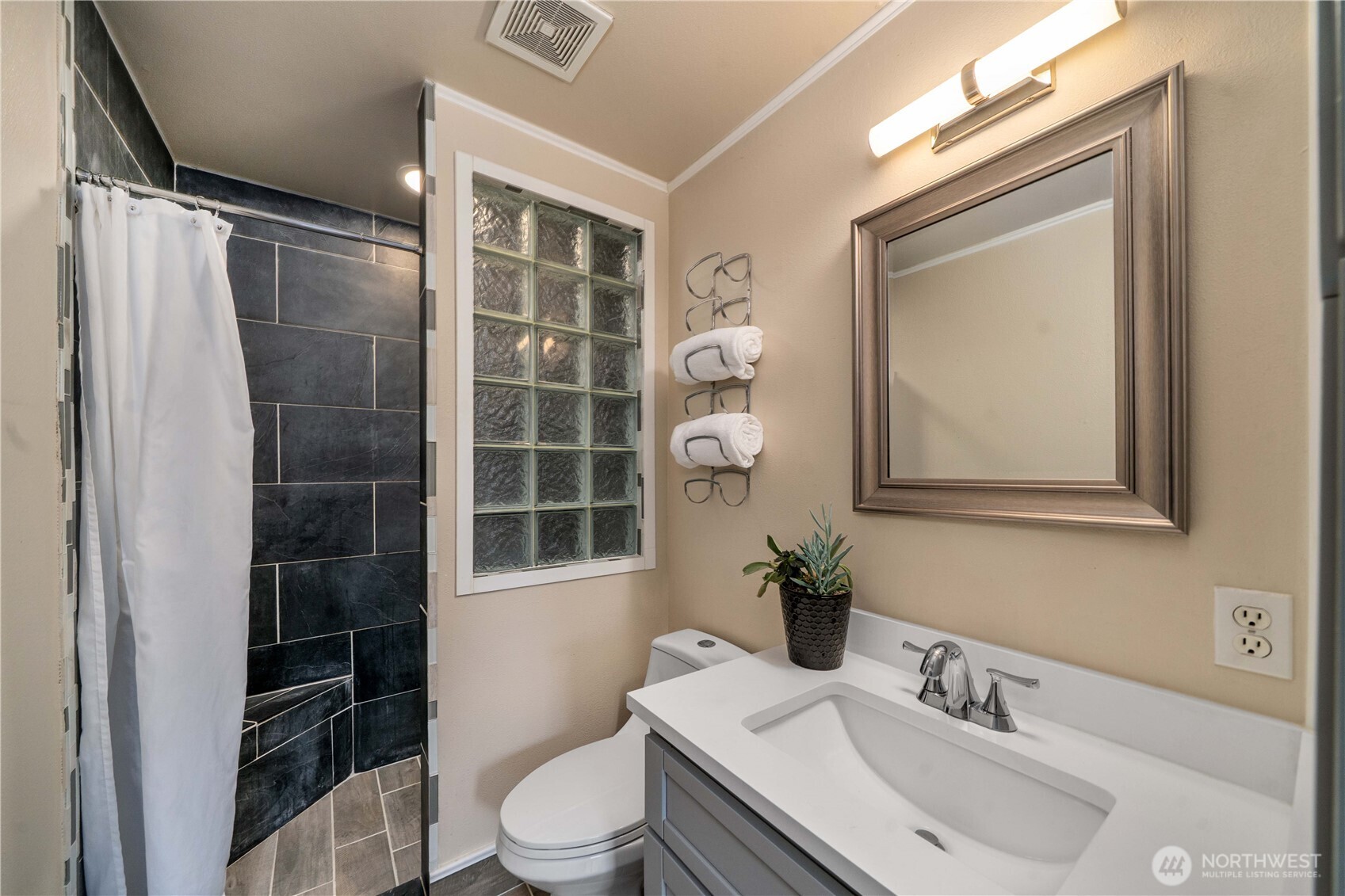 Walk-in shower with trendy vanity in the private primary.