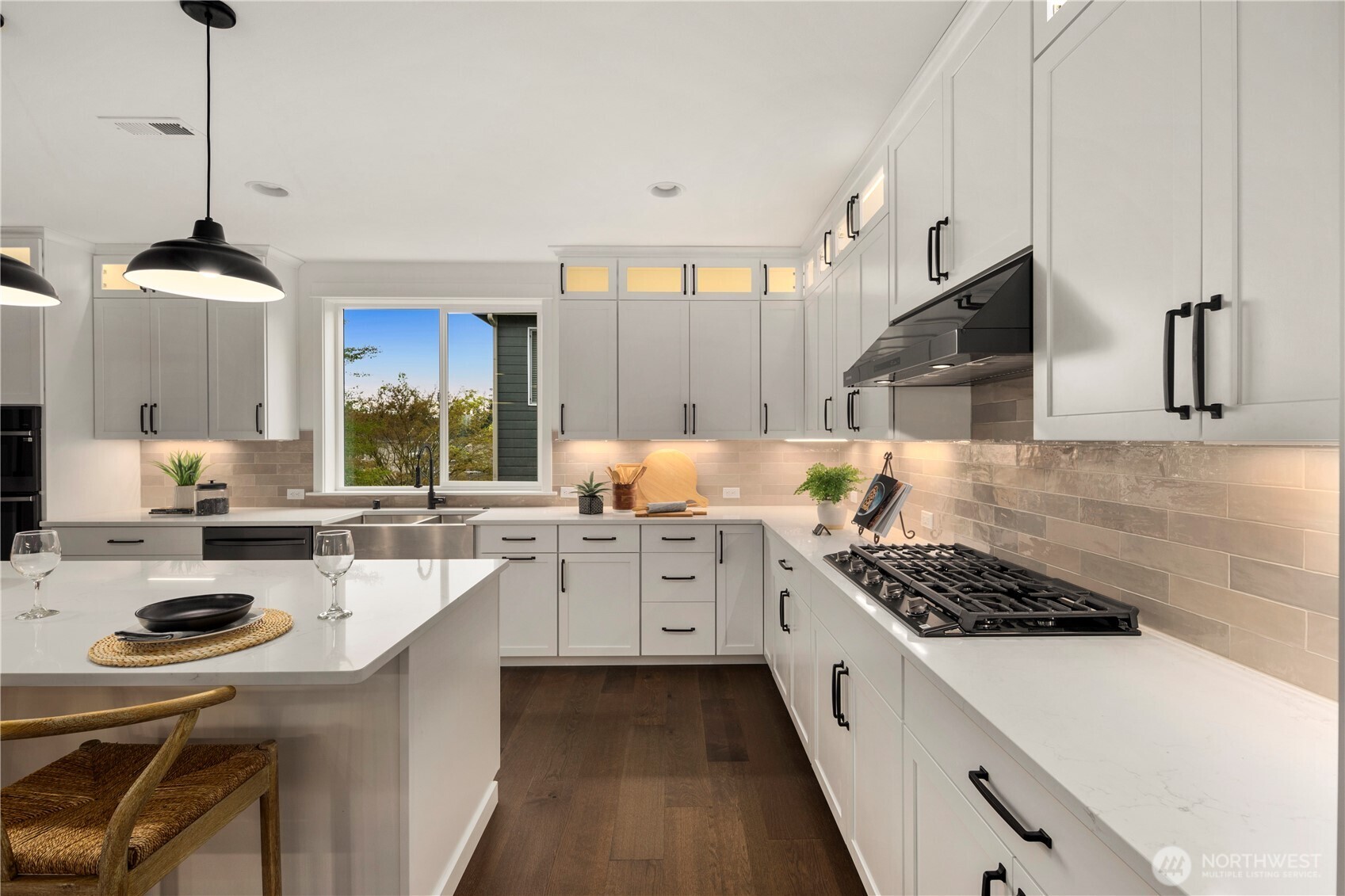 Kitchen Detail: Modern kitchen features a sleek gas cooktop with designer tile backsplash, abundant cabinetry, and quartz counters. Expansive prep space and high-end finishes create a stylish hub for culinary creativity.    Photos are from THIS model home at Foxmoore but are for visualization purposes only.