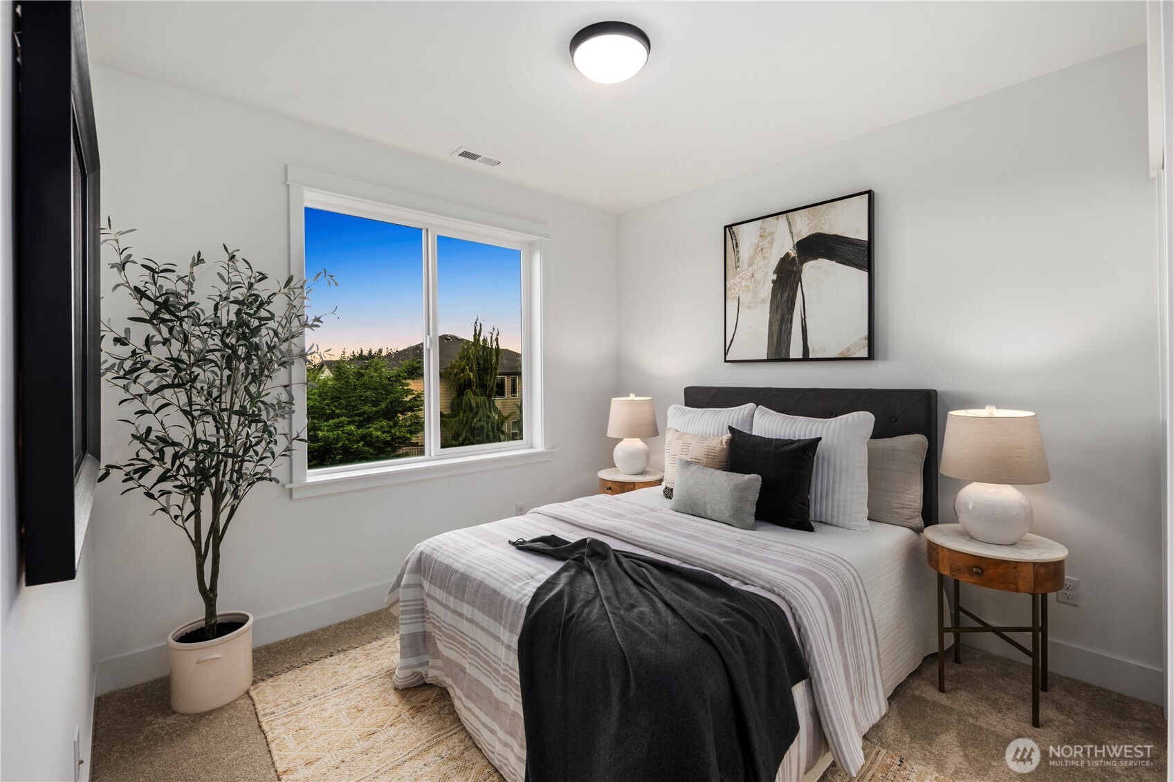 Main Floor Bedroom: Bright bedroom with oversized window showcases territorial views. Neutral palette and plush carpet create a welcoming retreat for family or guests.    Photos are from THIS model home at Foxmoore but are for visualization purposes only.
