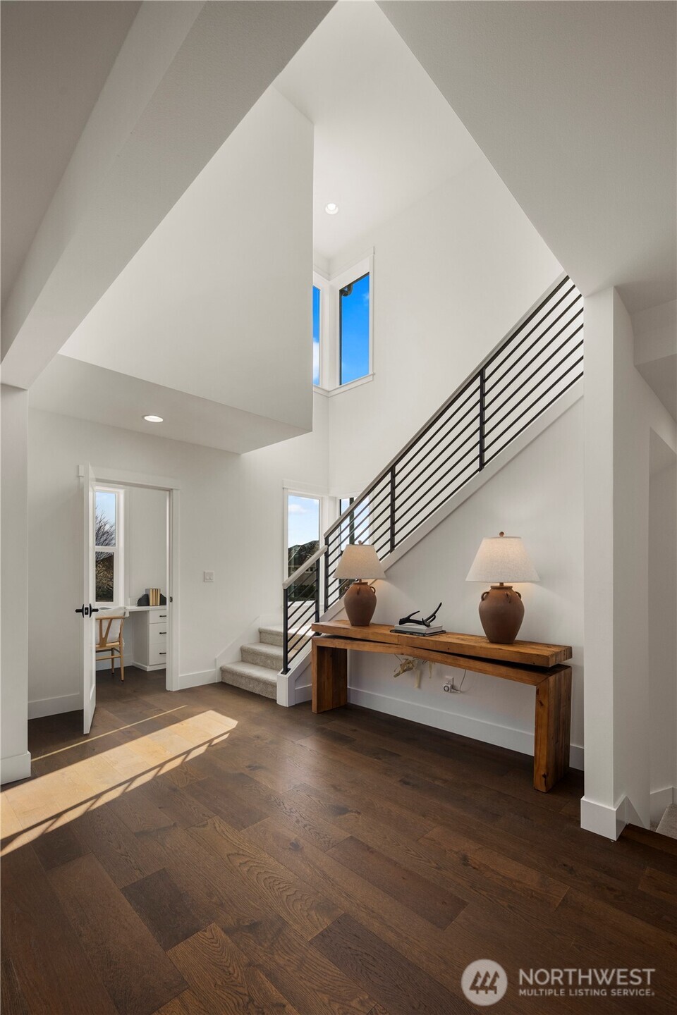 Main Level Landing: Open landing with soaring ceilings and sleek modern railing creates a bright, airy transition between levels. Large windows flood the space with natural light, offering a welcoming pause point that enhances the home’s spacious flow.    Photos are from THIS model home at Foxmoore but are for visualization purposes only.