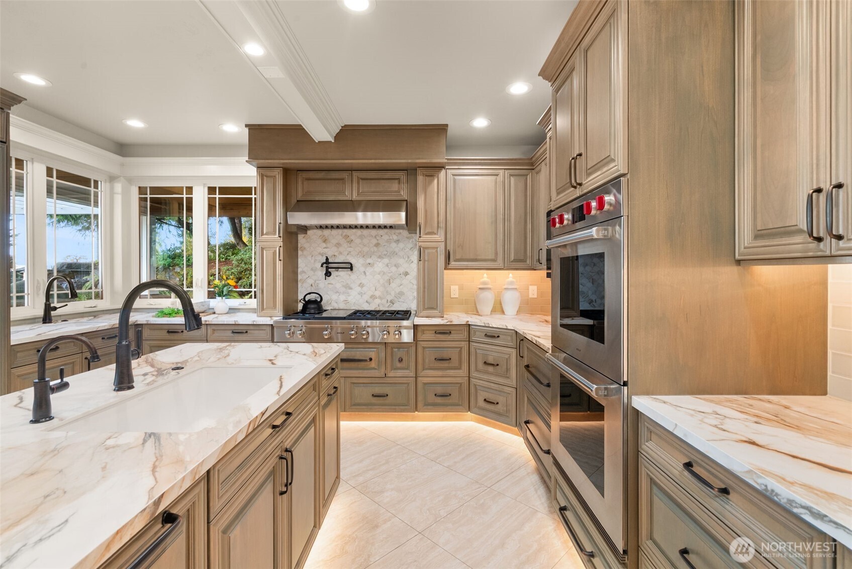 Expansive kitchen with porcelain slab counters and luxury appliances.