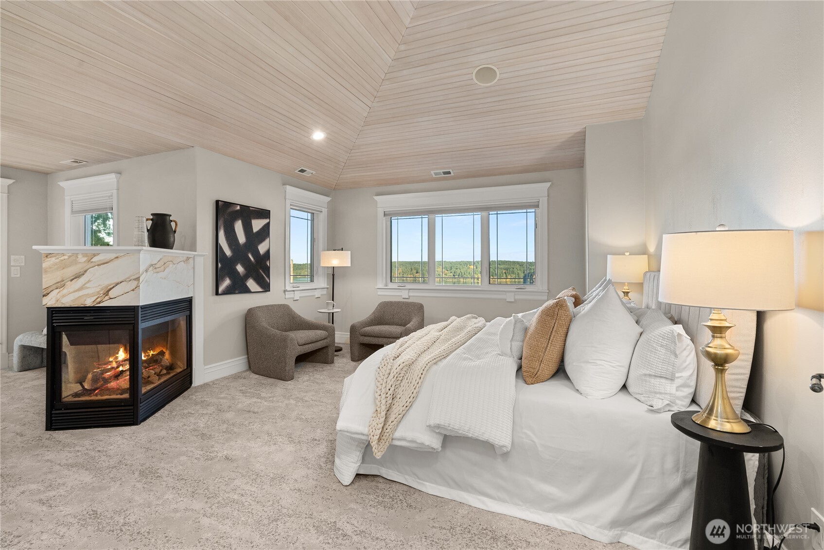 The primary suite has vaulted ceilings, a fireplace, sitting area and covered balcony.