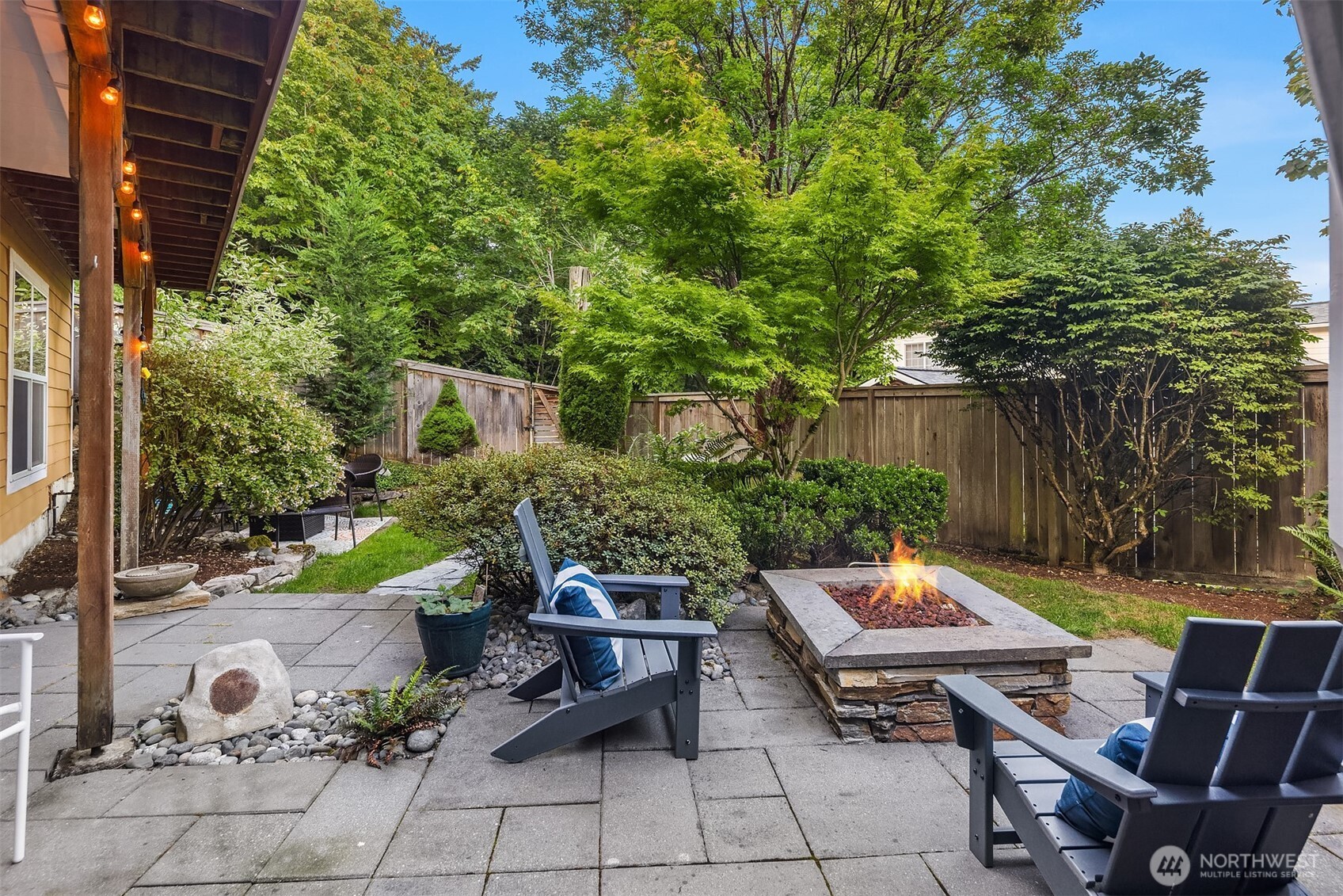 Pavers surround a built-in gas firepit in one of the many versatile entertaining spaces.