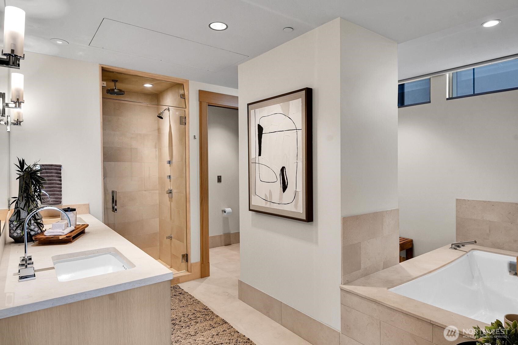 Stone countertops, heated tile floors, a soaking tub and steam shower are found in the Unit 1206 Primary bathroom
