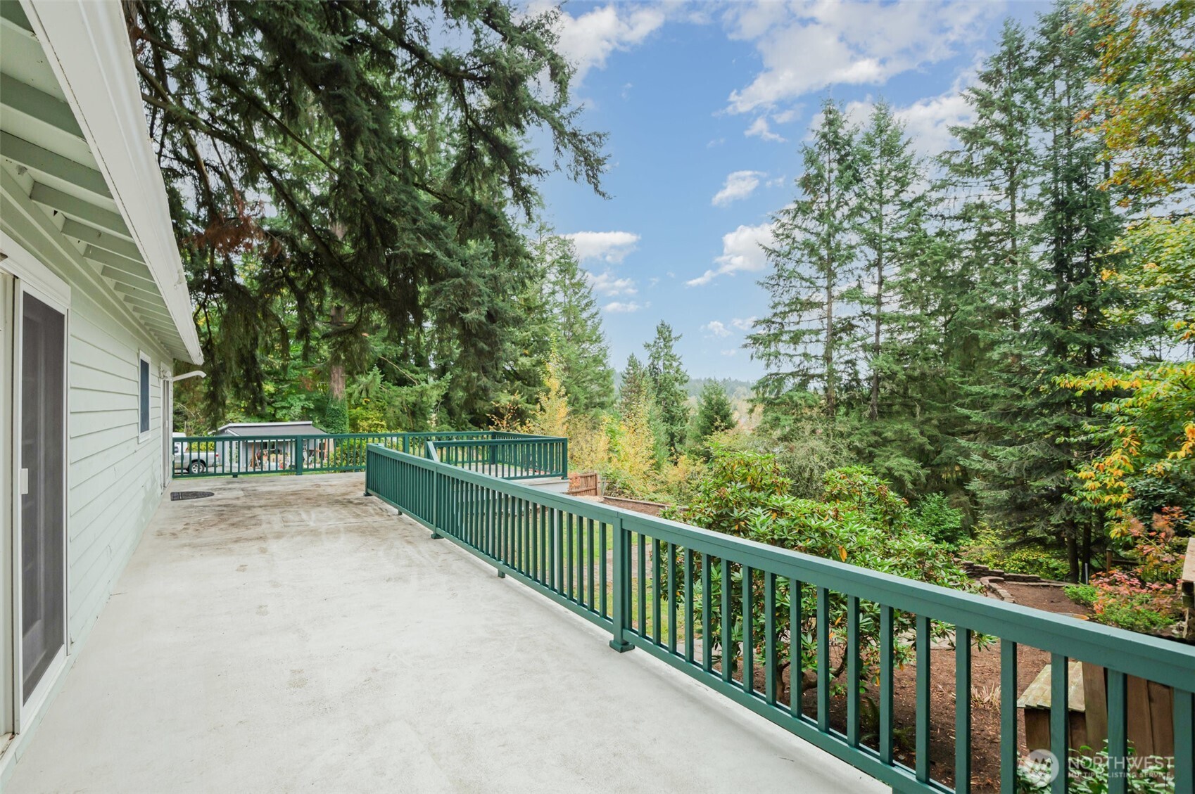 With two sets of French doors leading to a spacious, wraparound deck, this outdoor haven captures panoramic views of the surrounding mountains and shimmering Cottage Lake—an ideal retreat for relaxing or gathering with friends.