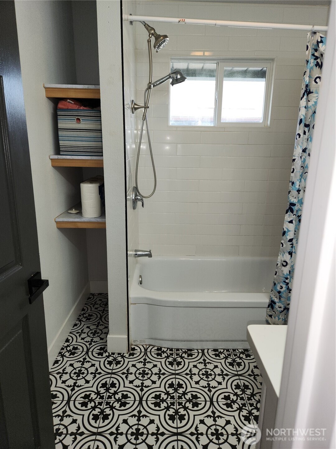 Storage space to the left of the tub/shower unit.