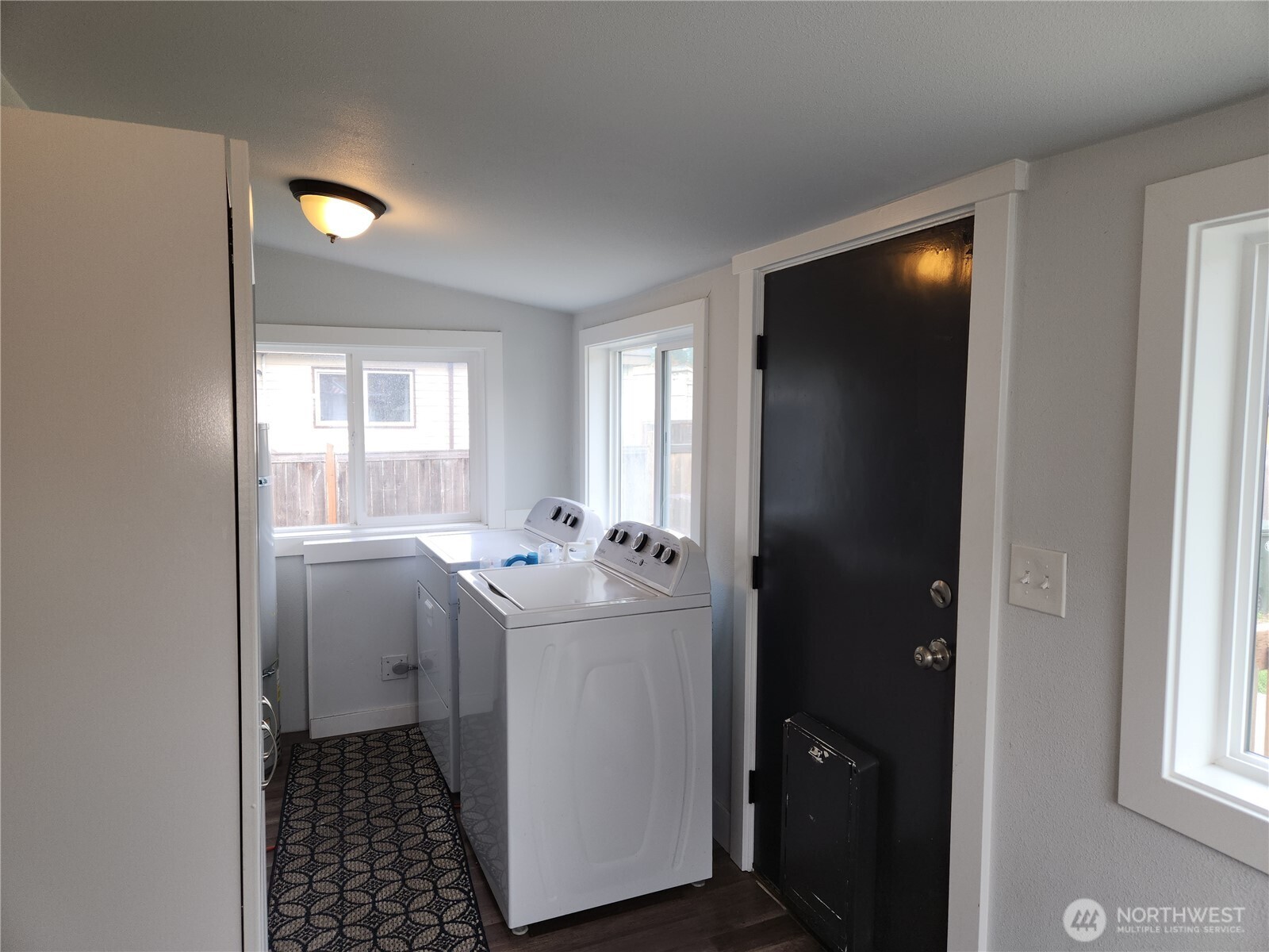 Utility room off the kitchen, washer and dryer and installed storage stays.  Notice the doggy door for convenience, if you have pets.