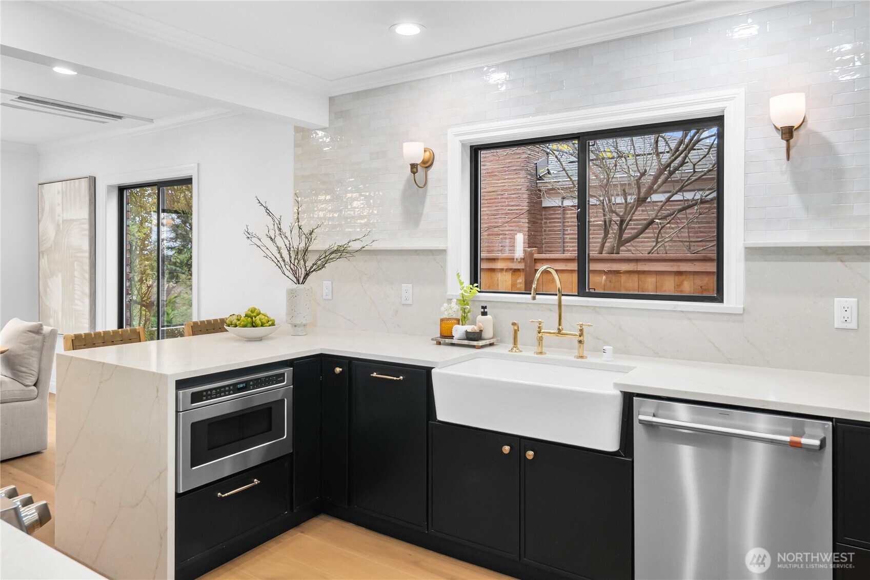 This photo showcases the quartz waterfall island, posh full-height quartz and tile backsplash...