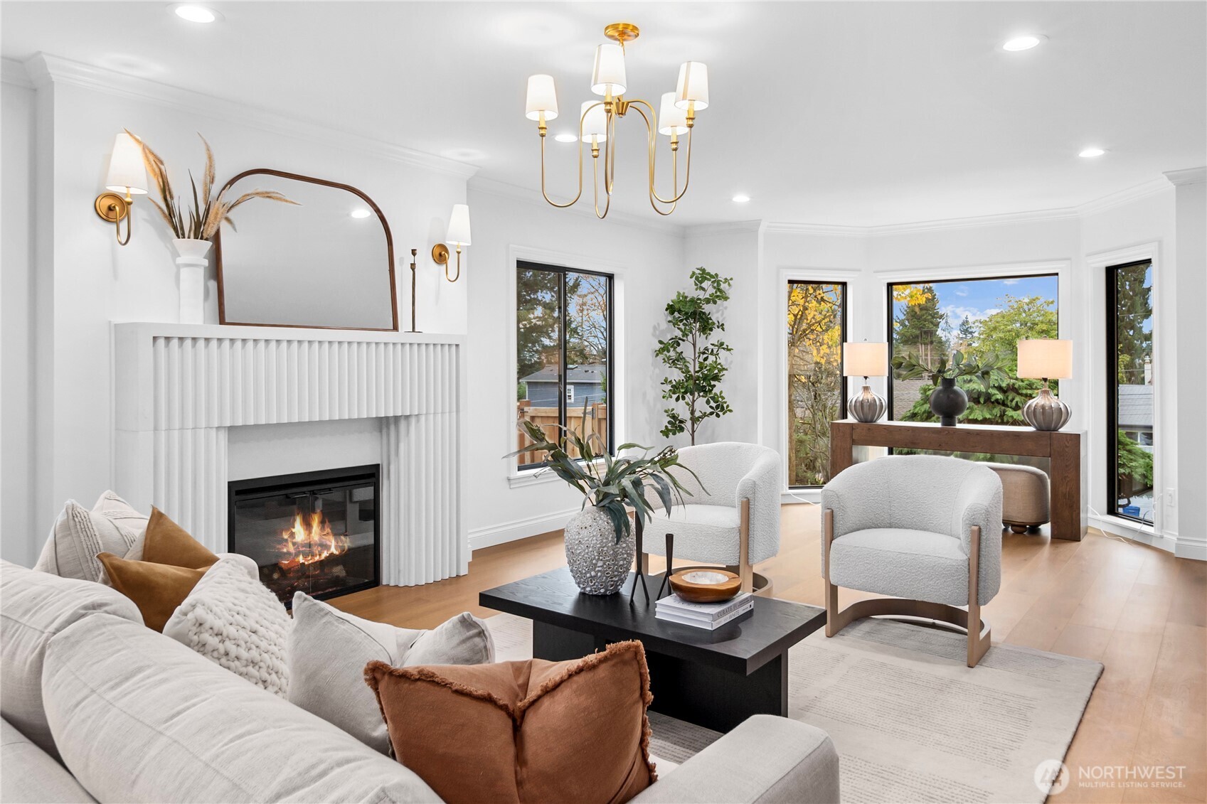 Very spacious living room with a view towards the Puget Sound; a very snazzy stone electric fireplace and stylish gold lighting fixtures...