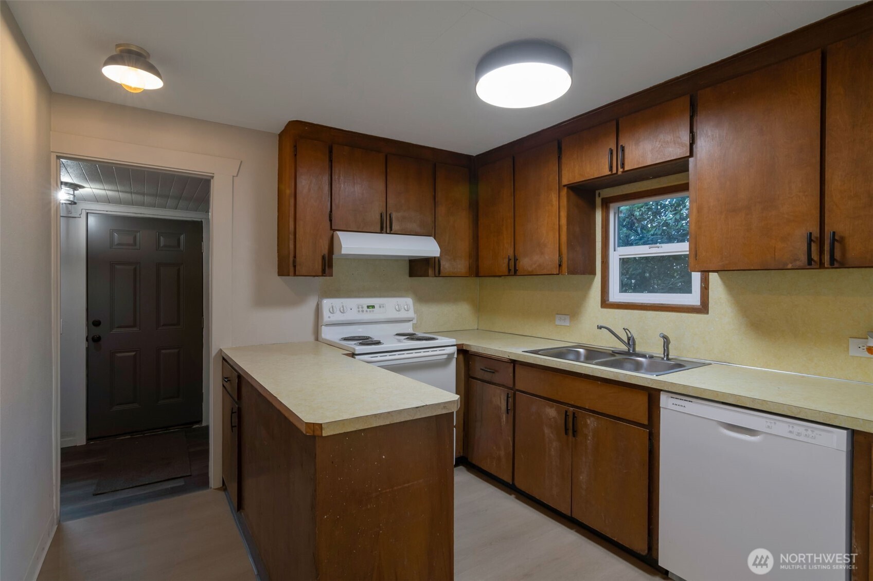 Kitchen with new appliances leads to rear mud room