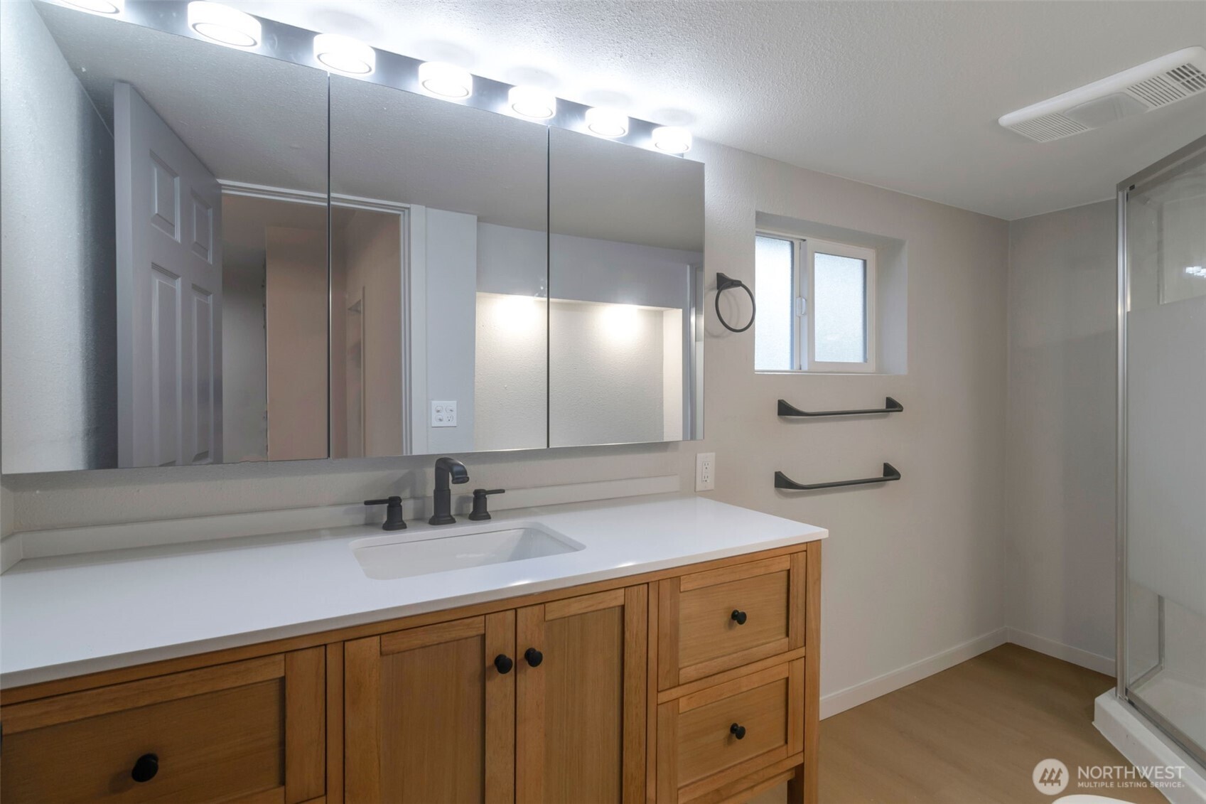 Fully remodeled bathroom on main floor with standing shower and 3 piece med cabinet mirrors