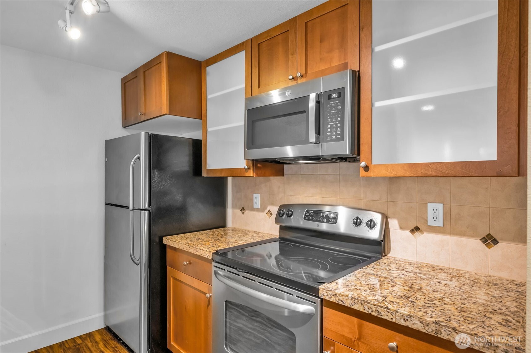 The kitchen has an amazing workspace. Enjoy shaker cabinets, new microwave, glass cooktop and tons of cabinet space. Granite counters and 1 compartment sink.  Tile accents make the space feel modern and clean up is a breeze.