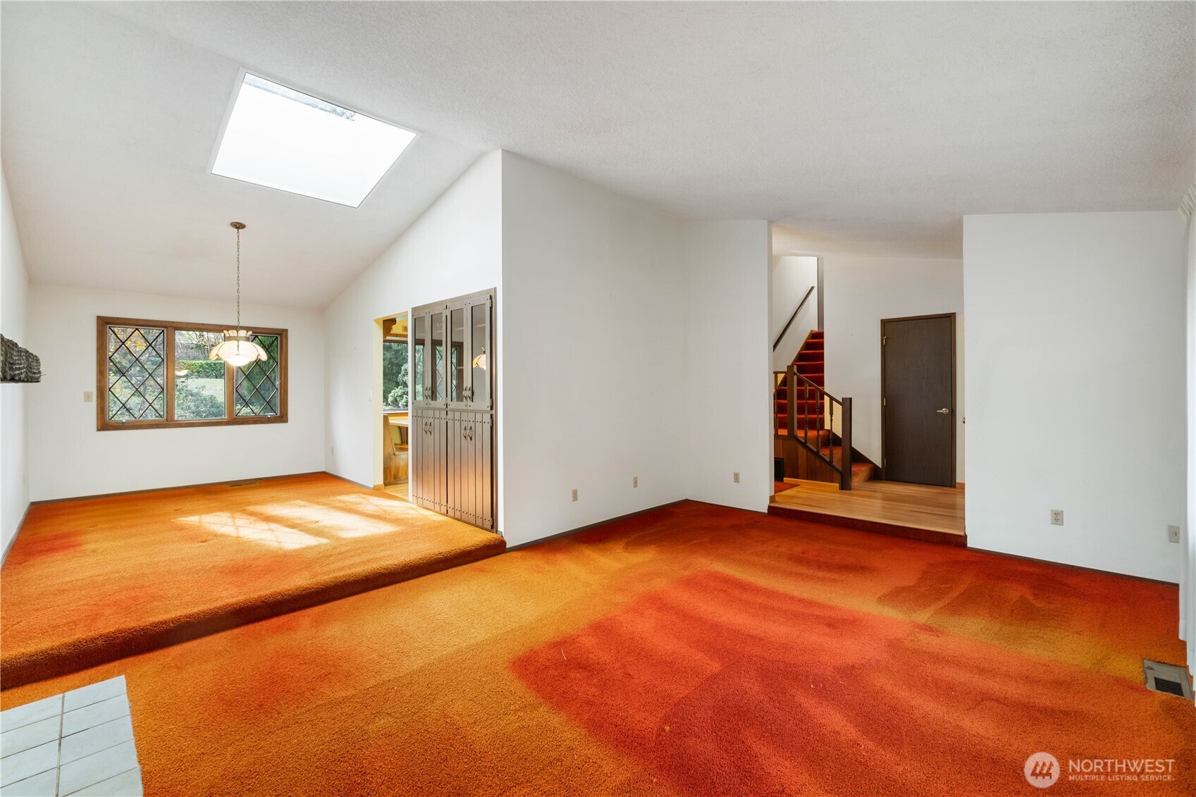 Un-staged view of living room, dining room, partial view of kitchen,entry and staircase to 2nd floor.
