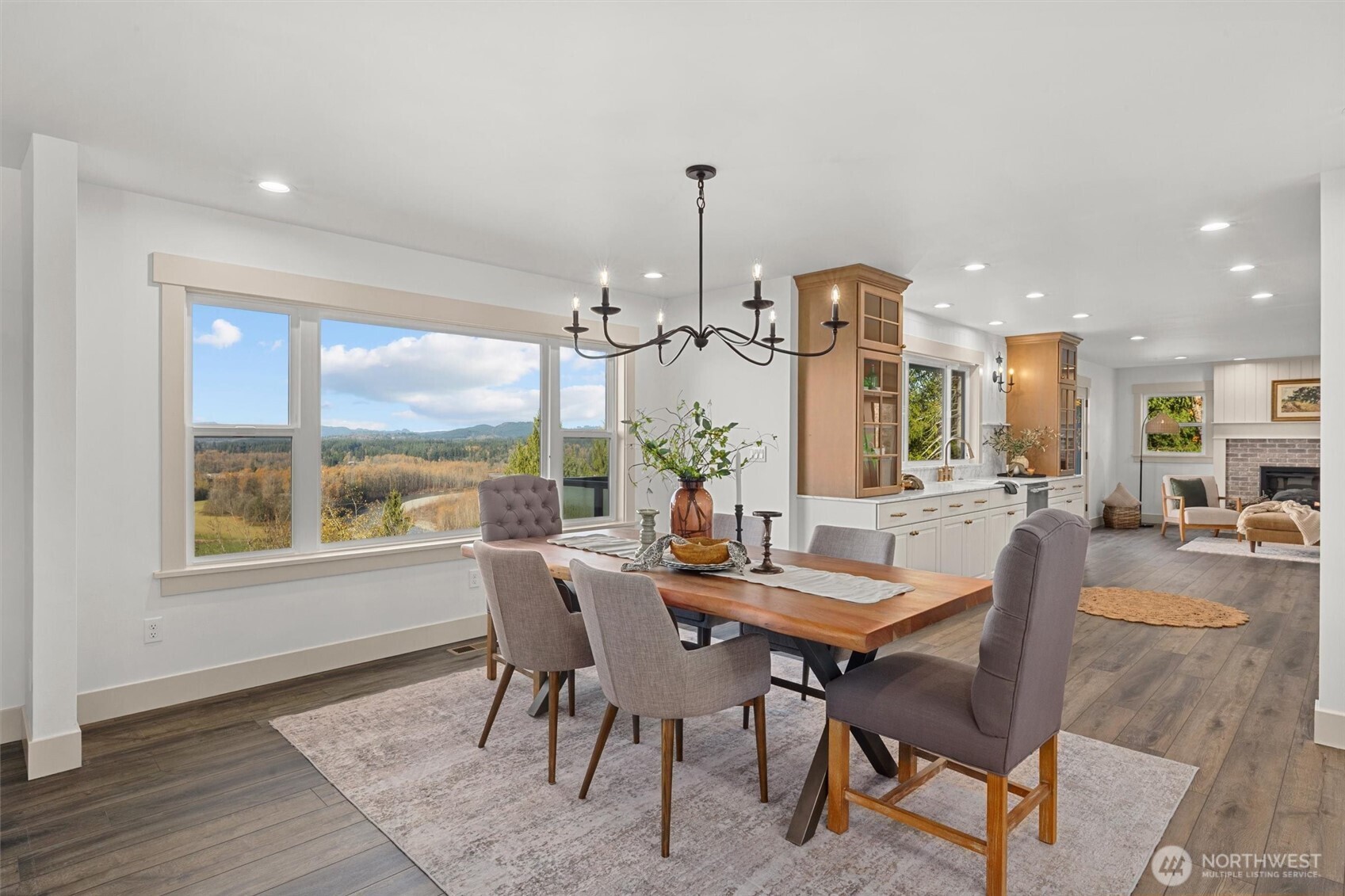 Elegant main floor dining room with timeless iron chandelier and recessed lighting.