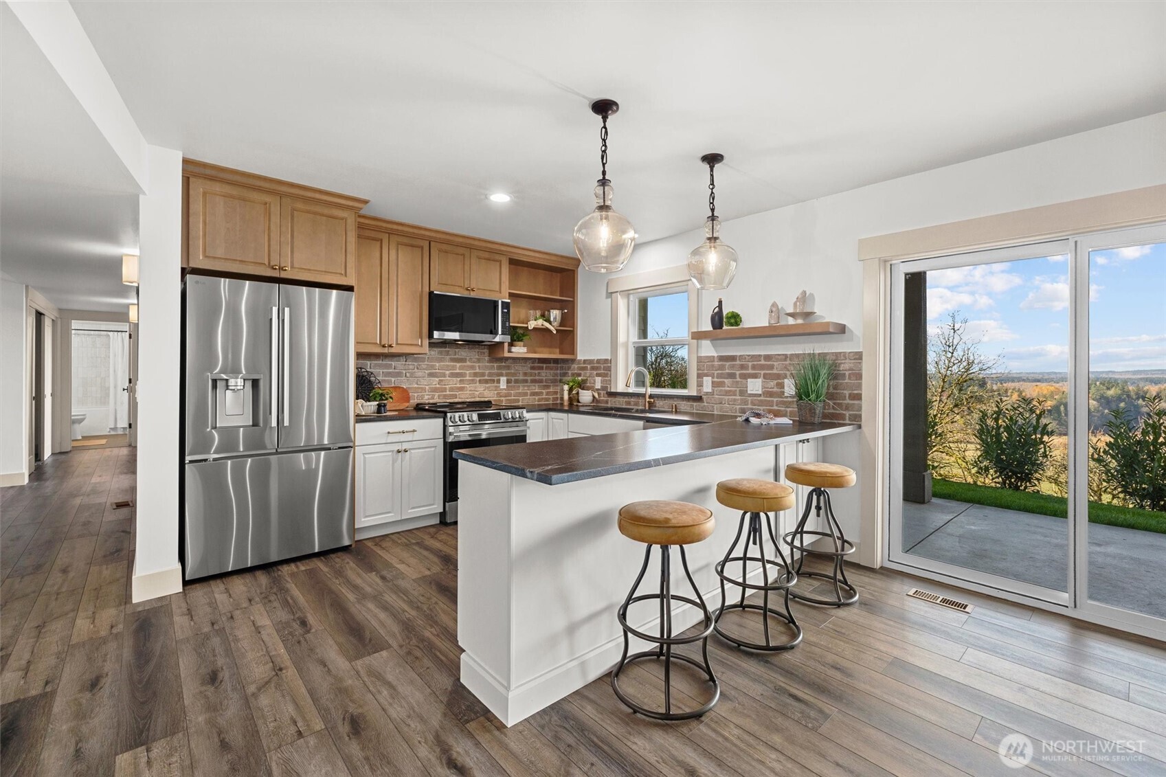 Beautiful custom kitchen with honed granite countertops, LG stainless steel appliance package, custom brick backsplash and bar seating! Perfect entertaining space or multigenerational living! Access to covered patio with amazing territorial views.