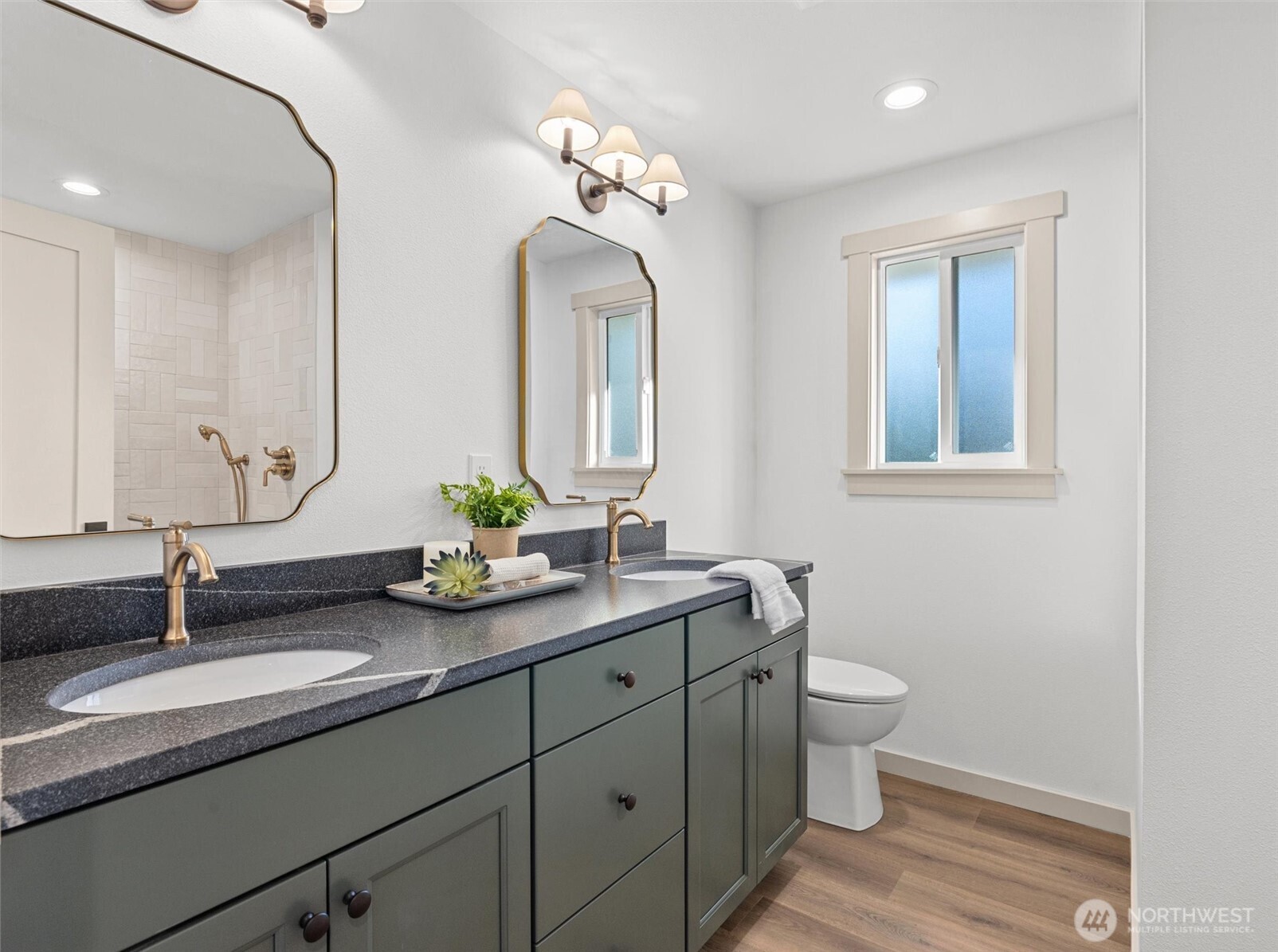 ADU bathroom with honed leather countertop, dual sinks, custom tile walk-in shower and high-end plumbing fixtures.