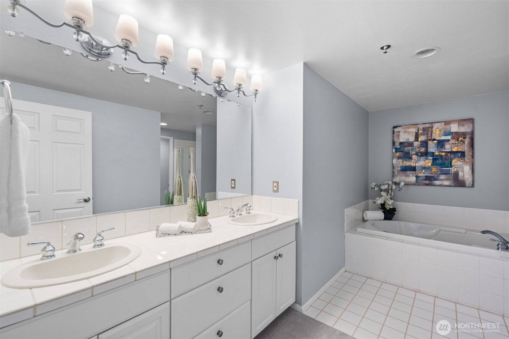 Unwind in the spa-like primary bathroom, featuring a dual vanity, sleek fixtures, and a glass-enclosed shower.