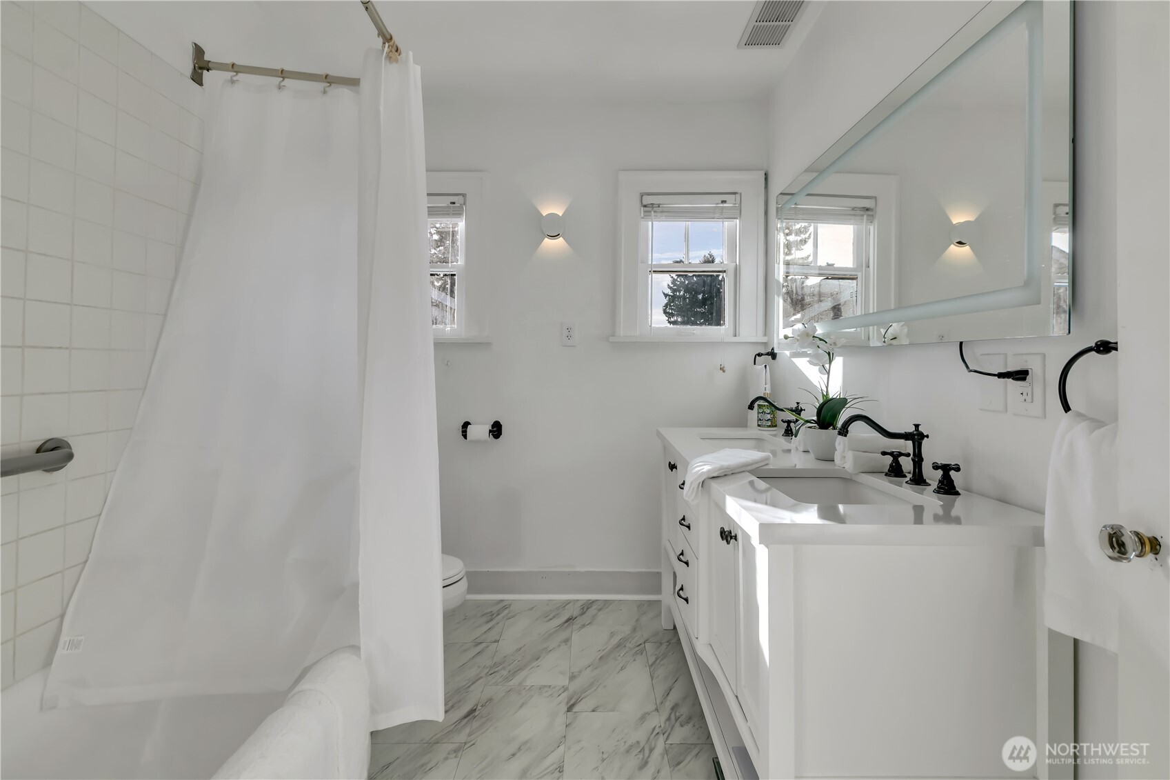 Updated main-level full bath featuring the original cast-iron tub.