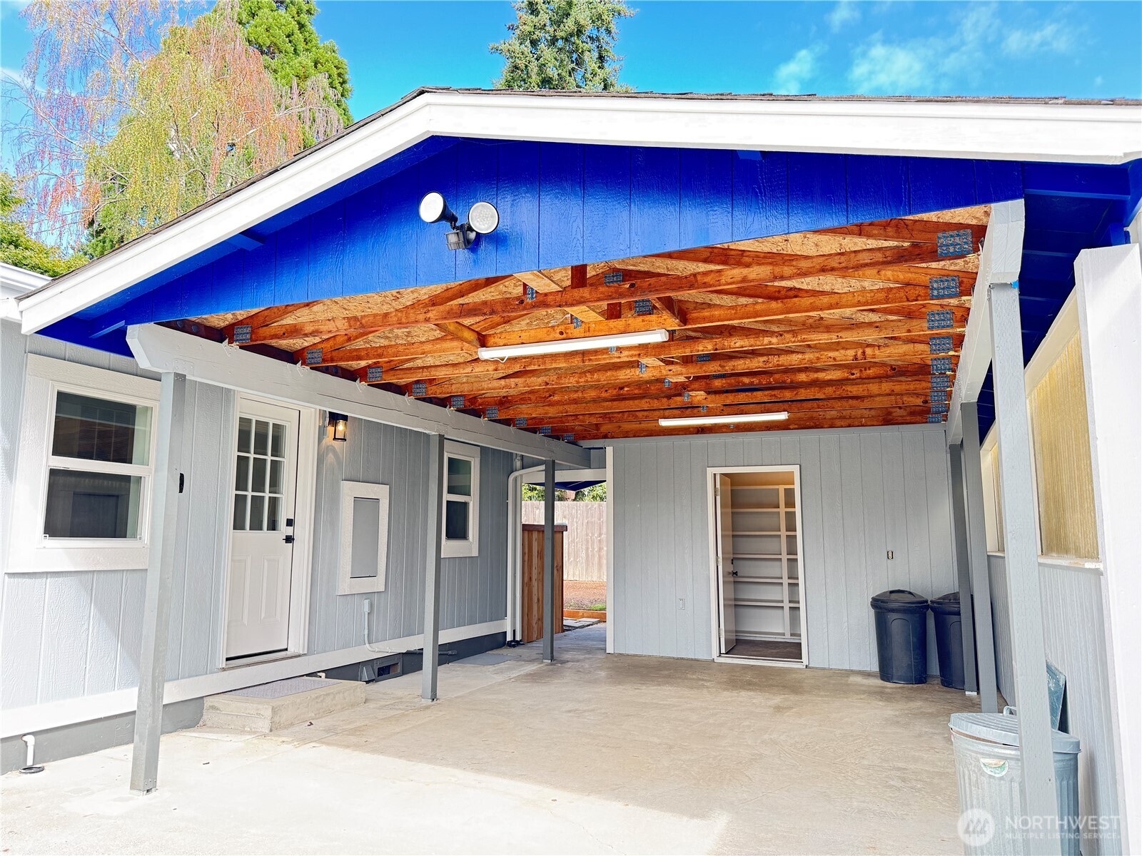 Large carport with two attached sheds.