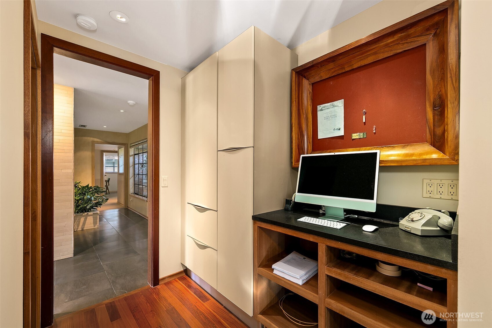 A built-in home-organization center sits just off the kitchen, with custom cabinetry designed to echo the clean lines of the Snaidero system. Honed black-granite counters, mahogany detailing and thoughtful storage create an efficient hub that connects the kitchen to the hallway and utility spaces.
