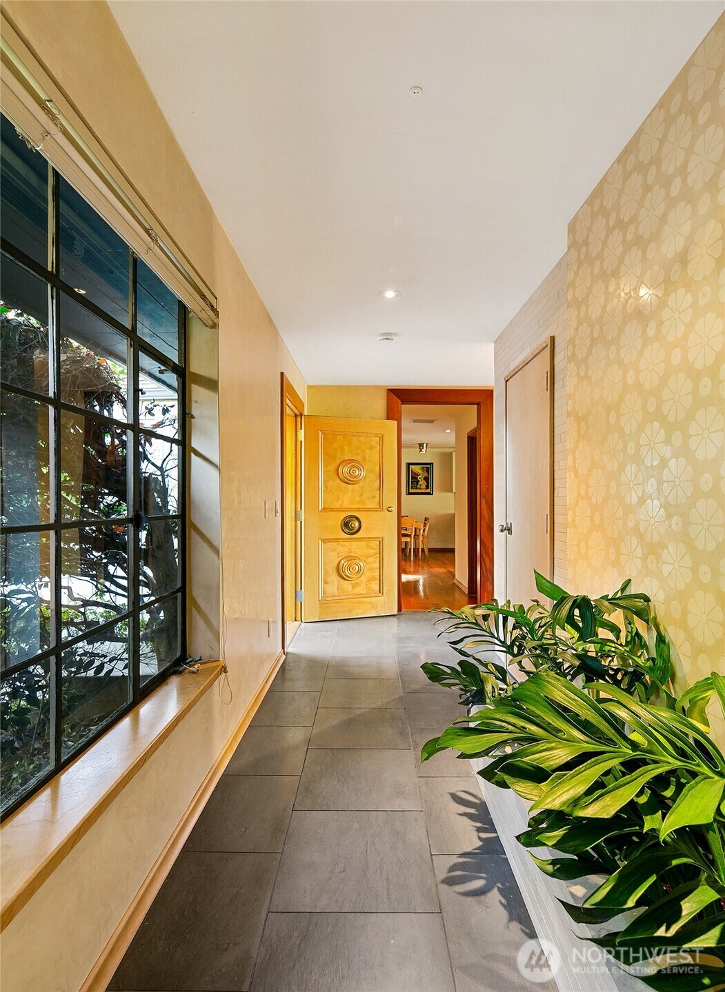 A light-washed passage anchors the home’s internal rhythm, where Venetian-plastered walls and the irrigated planter create a soft threshold between interior calm and the pathways that lead outdoors. From here the circulation extends naturally toward the home’s secondary structures including the bungalow, inviting an easy flow between living spaces and the garden beyond.