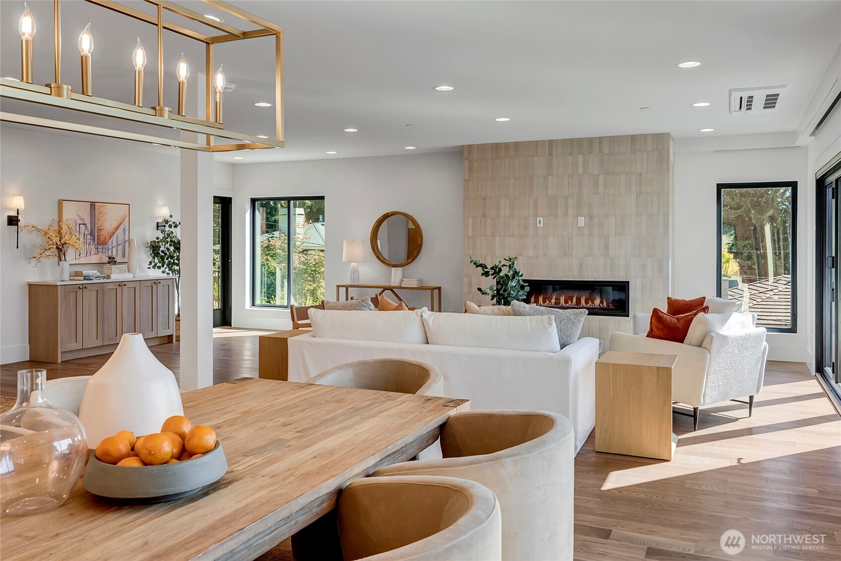 This true great room flows seamlessly from the kitchen into the family room, where a sleek modern fireplace creates a warm and inviting anchor for the space. The open layout is bright, comfortable and perfect for gathering, with easy connection to the dining area and outdoor living.