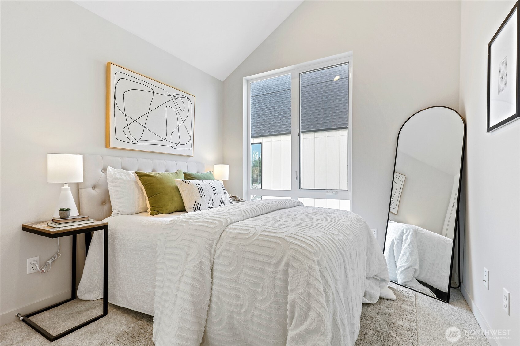 This dreamy bedroom is a sunlit retreat featuring vaulted ceilings, large windows, and just the right amount of personality.