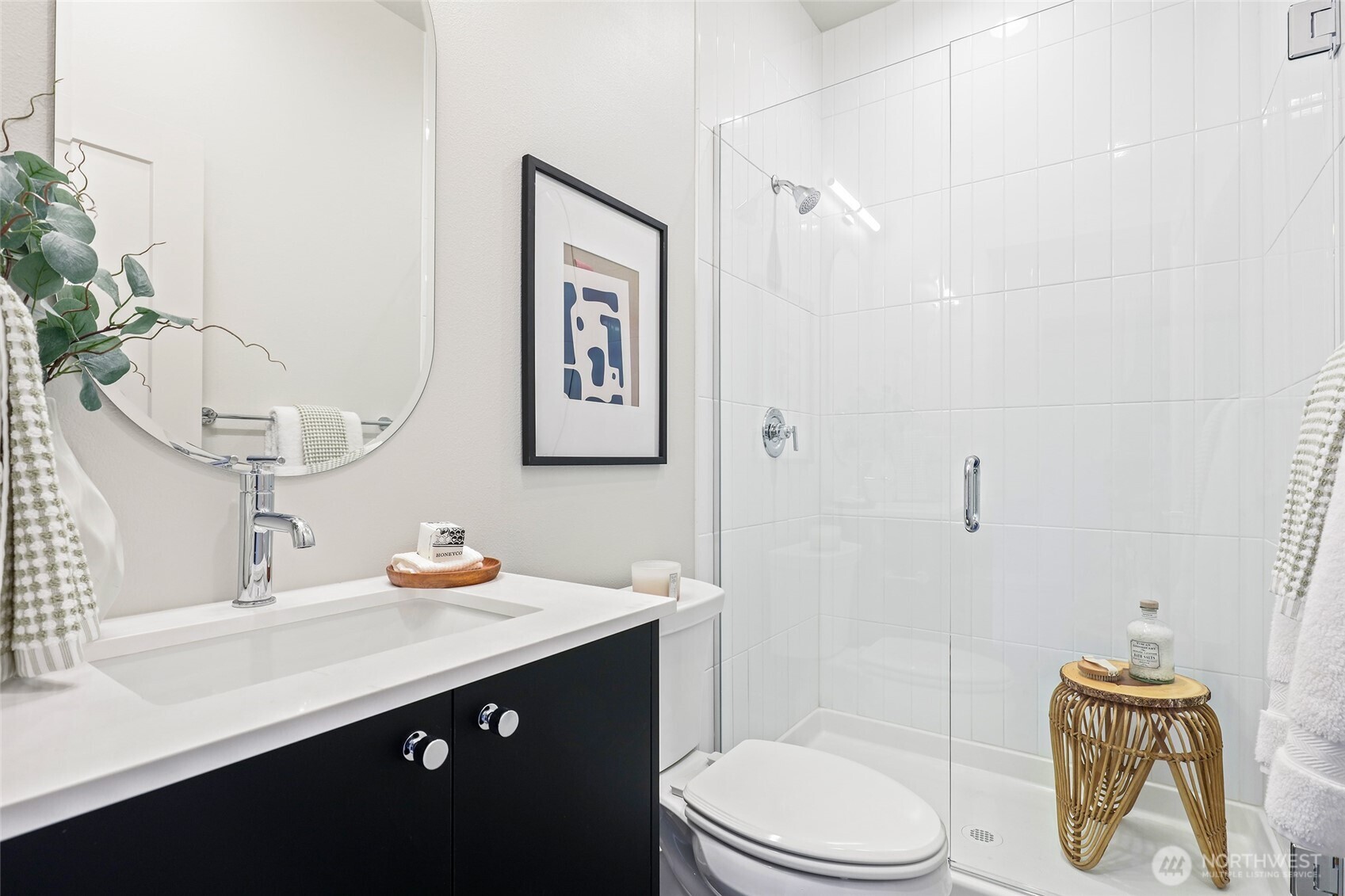 Another sleek bathroom that nails the balance of simplicity and style — modern tile, matte black cabinetry, and glass shower.