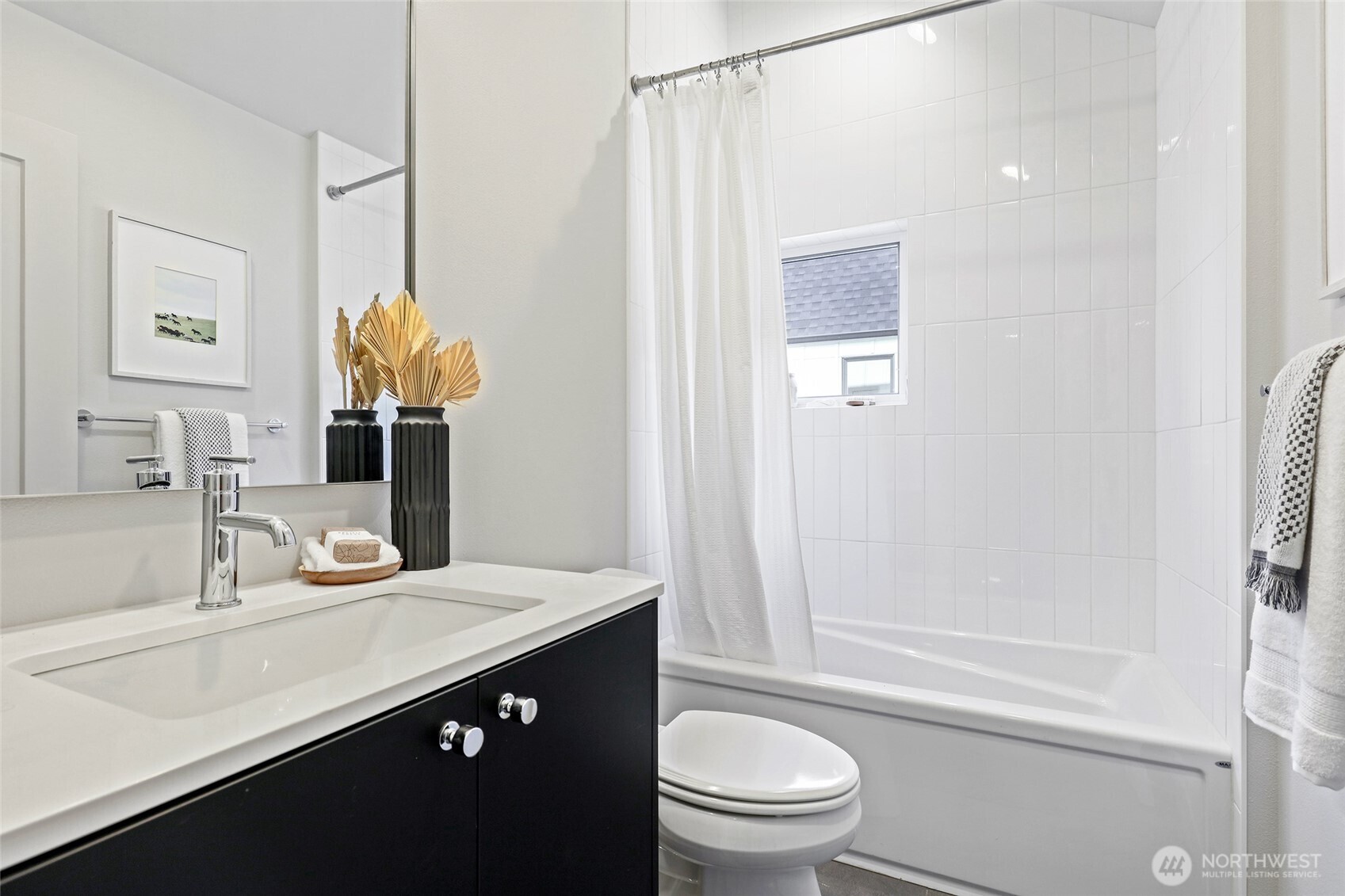 This fresh and modern full bath has sleek finishes, thoughtful storage, and plenty of natural light—perfect for guests or daily routines.