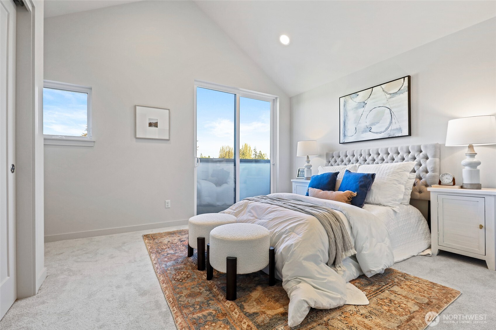 Vaulted ceilings, a wall of windows, and private balcony access make this primary suite feel like a breath of fresh air.