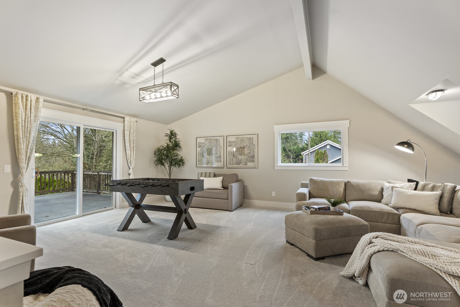 Another view of the bonus room that has access to the back deck and a second set of stairs leading to the lower level