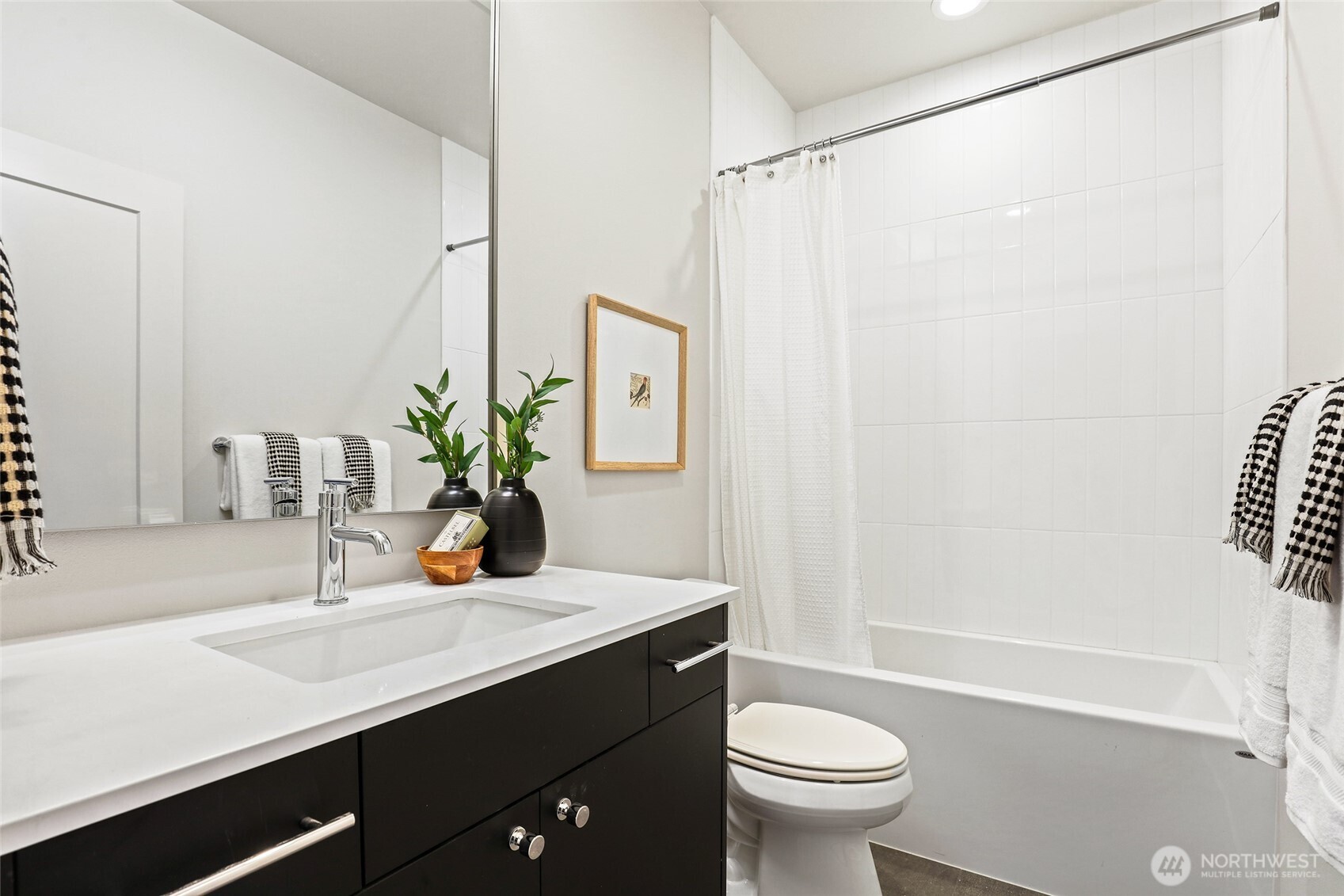 Photos of model home 9752 with similar finishes & floor plan. This full bath offers stylish finishes and sleek functionality—perfectly placed near the separated guest quarters.