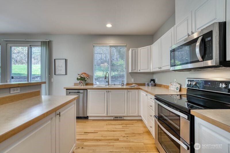 View of the kitchen showing counter space, large window, and sliding door.  Plenty of light!