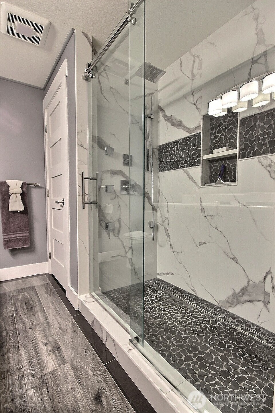 The walk-in shower features a heated stone floor, relaxing rain shower heads, and body sprays. The bathroom closet stores all your towels and other items.