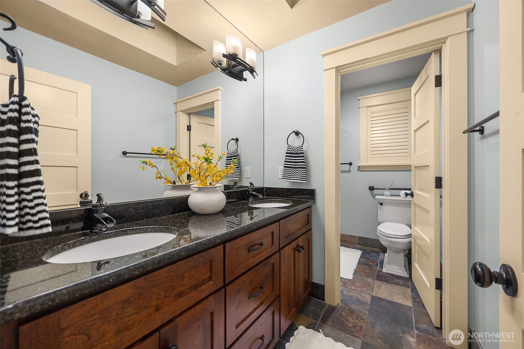 Another full bath in the upper level with an additional private door and custom shutters
