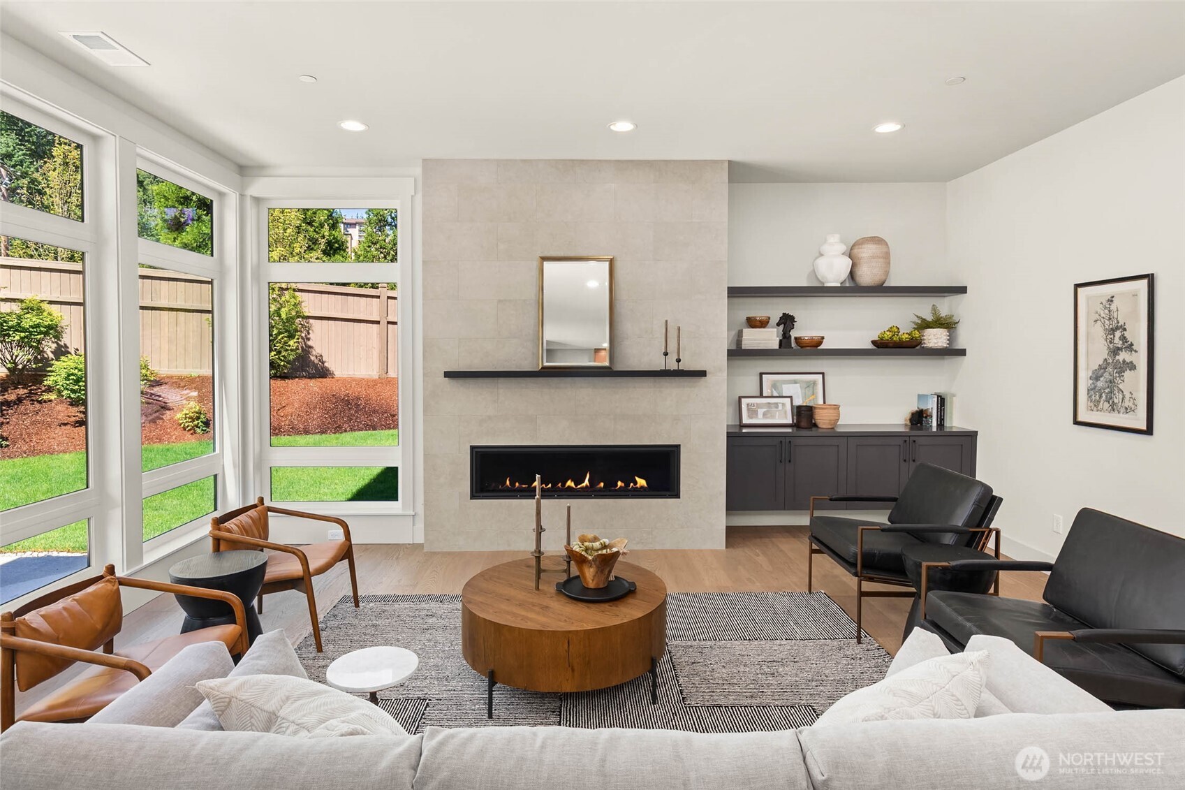 Great room further highlighted by slab topped custom floating cabinets with matching floating display shelves