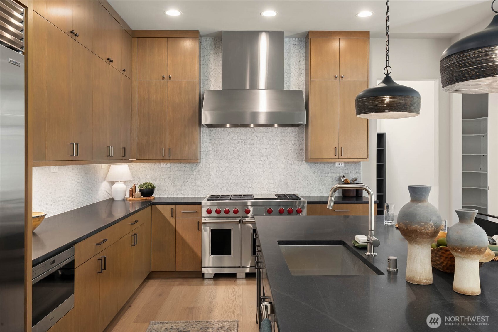Wolf and Subzero appliance package features Sub Zero 42" side by side built in fridge/freezer, 48" Wolf Duel Fuel Gas range with griddle and 6 burners, sub zero undercounter glass front beverage fridge, Wolf 24" drawer microwave, and Cove dishwasher.