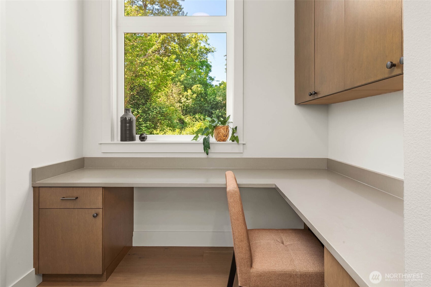 Convenient E-Space off the kitchen with slab desk and custom lower and upper cabinets connects kitchen and pantry