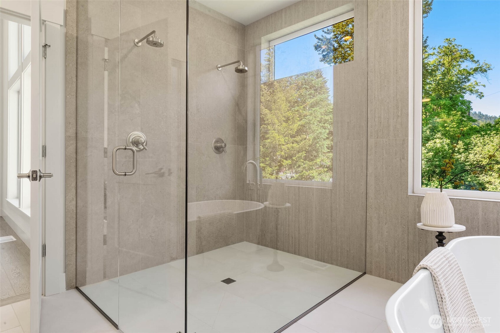 Large walk in shower with floor to ceiling designer selected tile and frameless glass surround