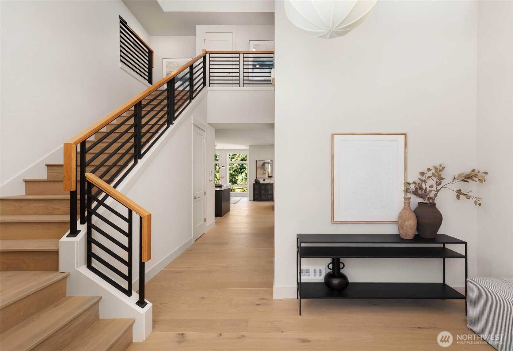 Wide open 2 story entry features custom open rail design and designer selected hanging light fixture
