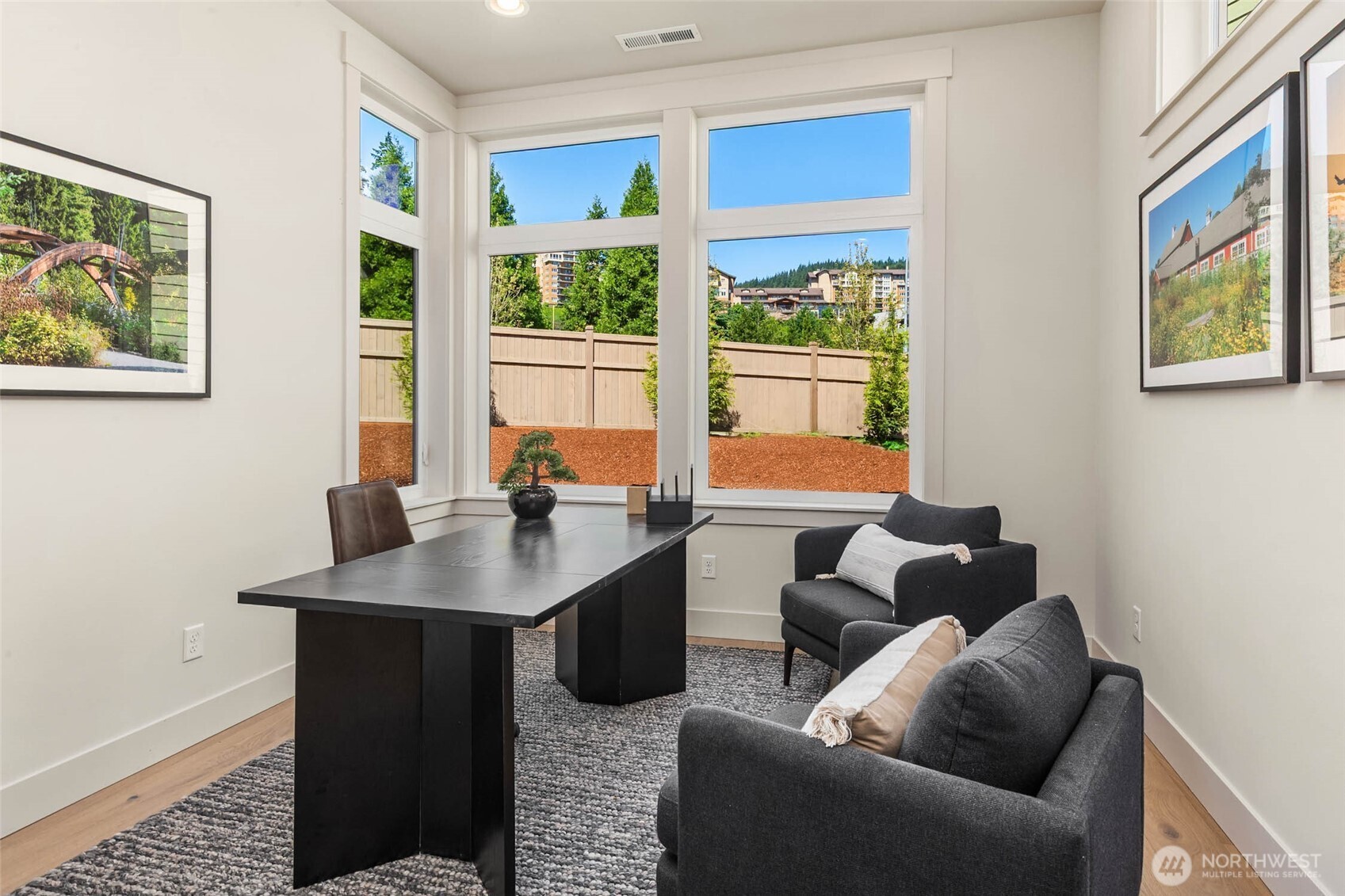 Main floor office or 5th bedroom with wide plank hardwood flooring and closet with custom solid shelving