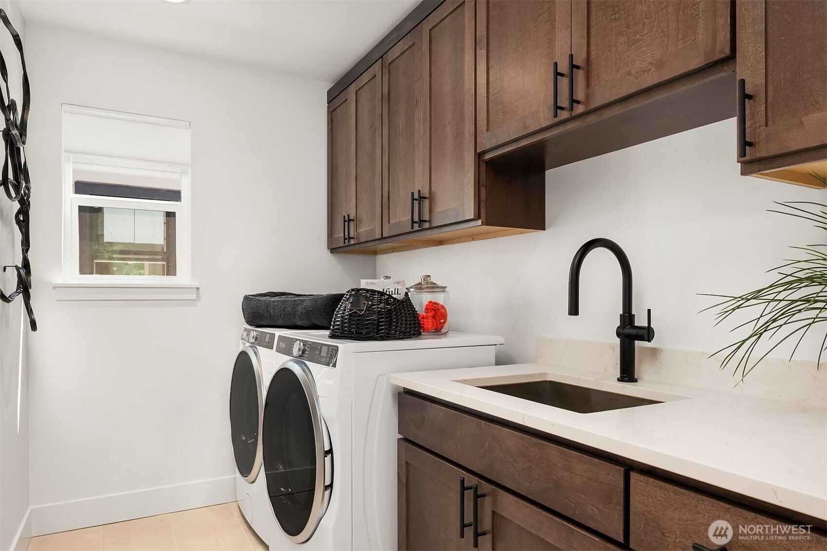 Laundry room is conveniently located upstairs and has beautuful cabinetry, utility sink and comes with a front loading washer and dryer