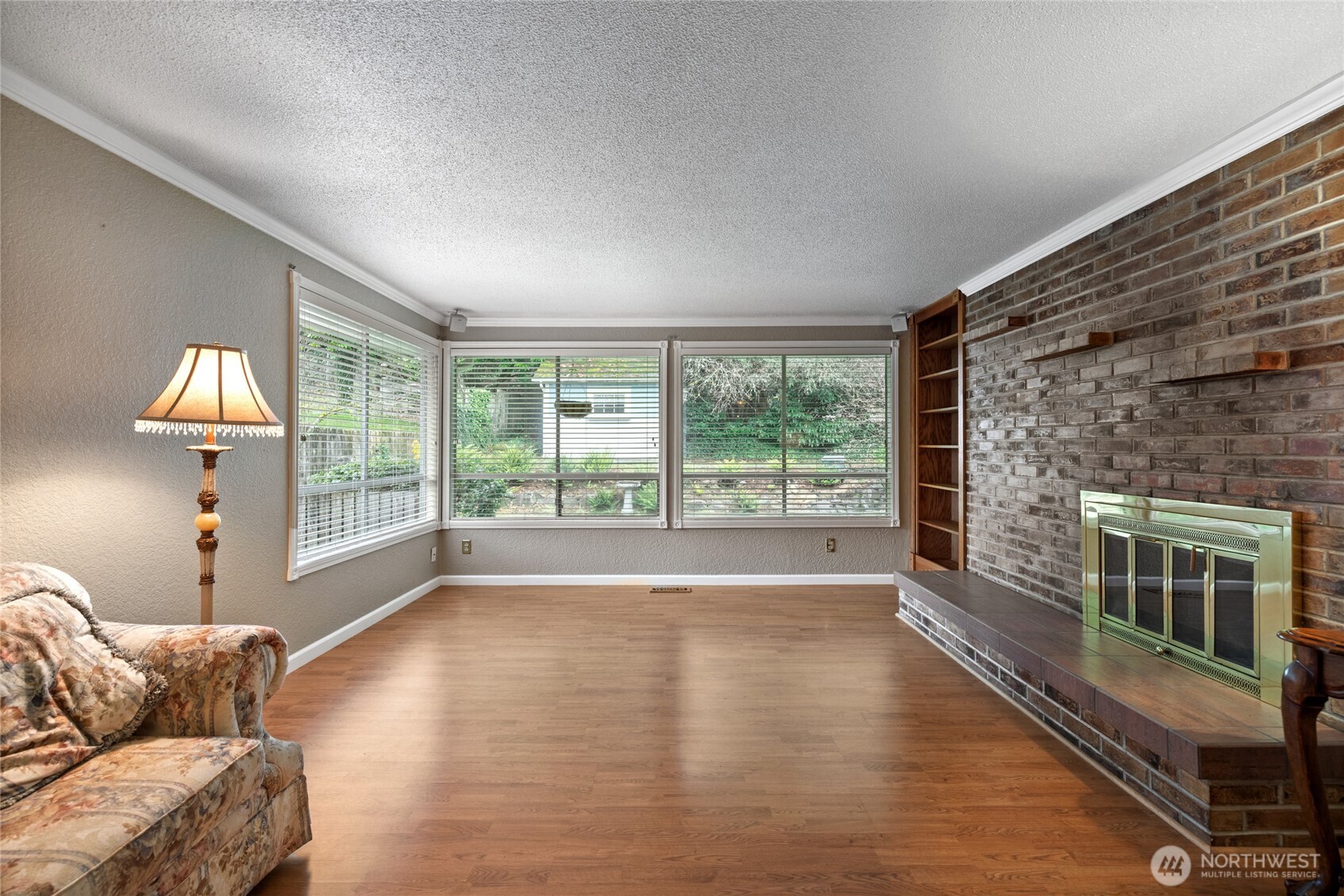 Living Room / Great Room ample natural light beaming throughout the room. Built in book case and wood fireplace.