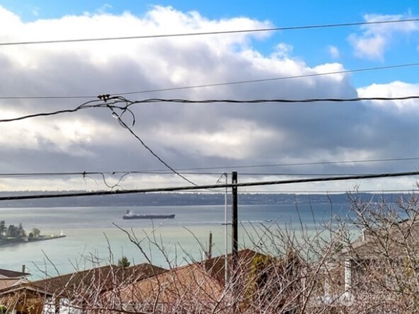 Living room with great wood stove. Vaulted ceilings, open concept into dining area and kitchen