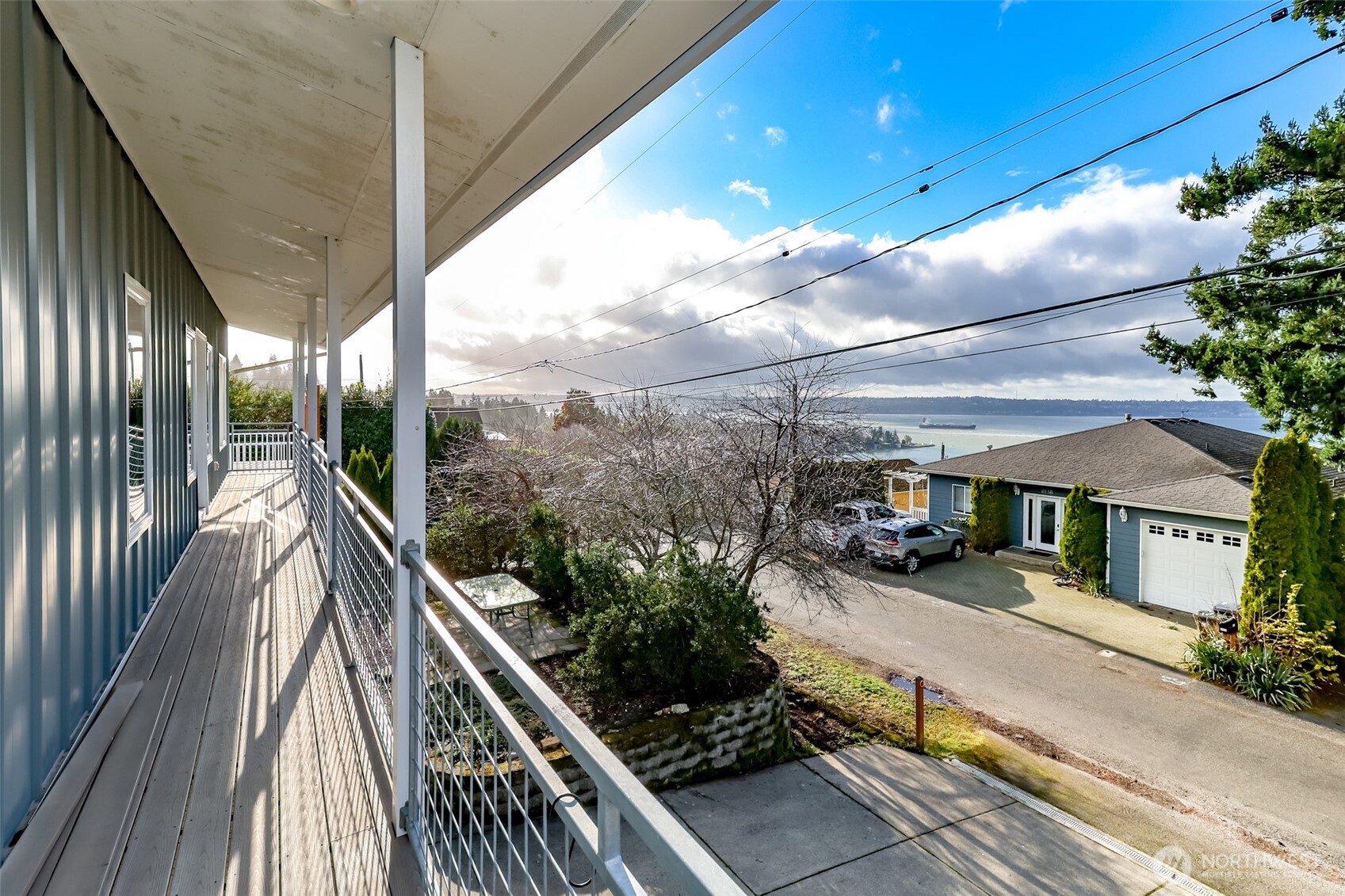 Living room with White oak hardwood floors, skylights and ceiling fans and doors out to deck.