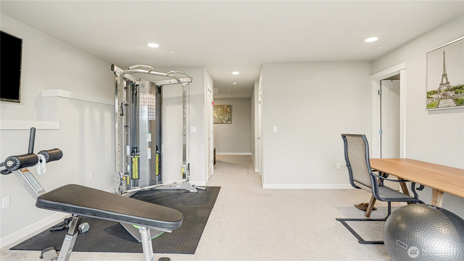 Room is filled with natural light, enhanced by recessed lighting and a continued neutral color palette.