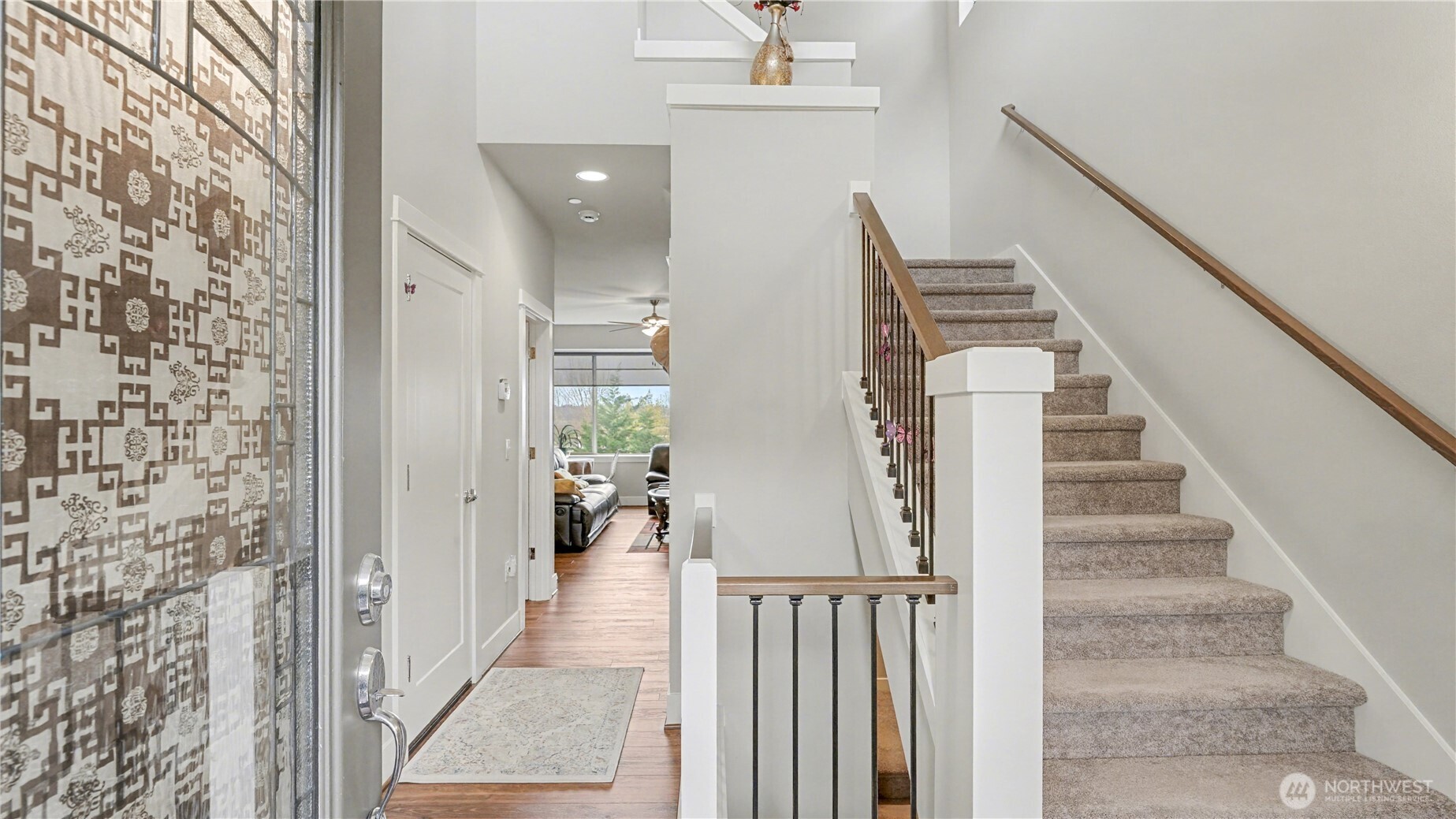 Home enters into the main floor, greeted by vaulted ceilings and a warm neutral color palette.