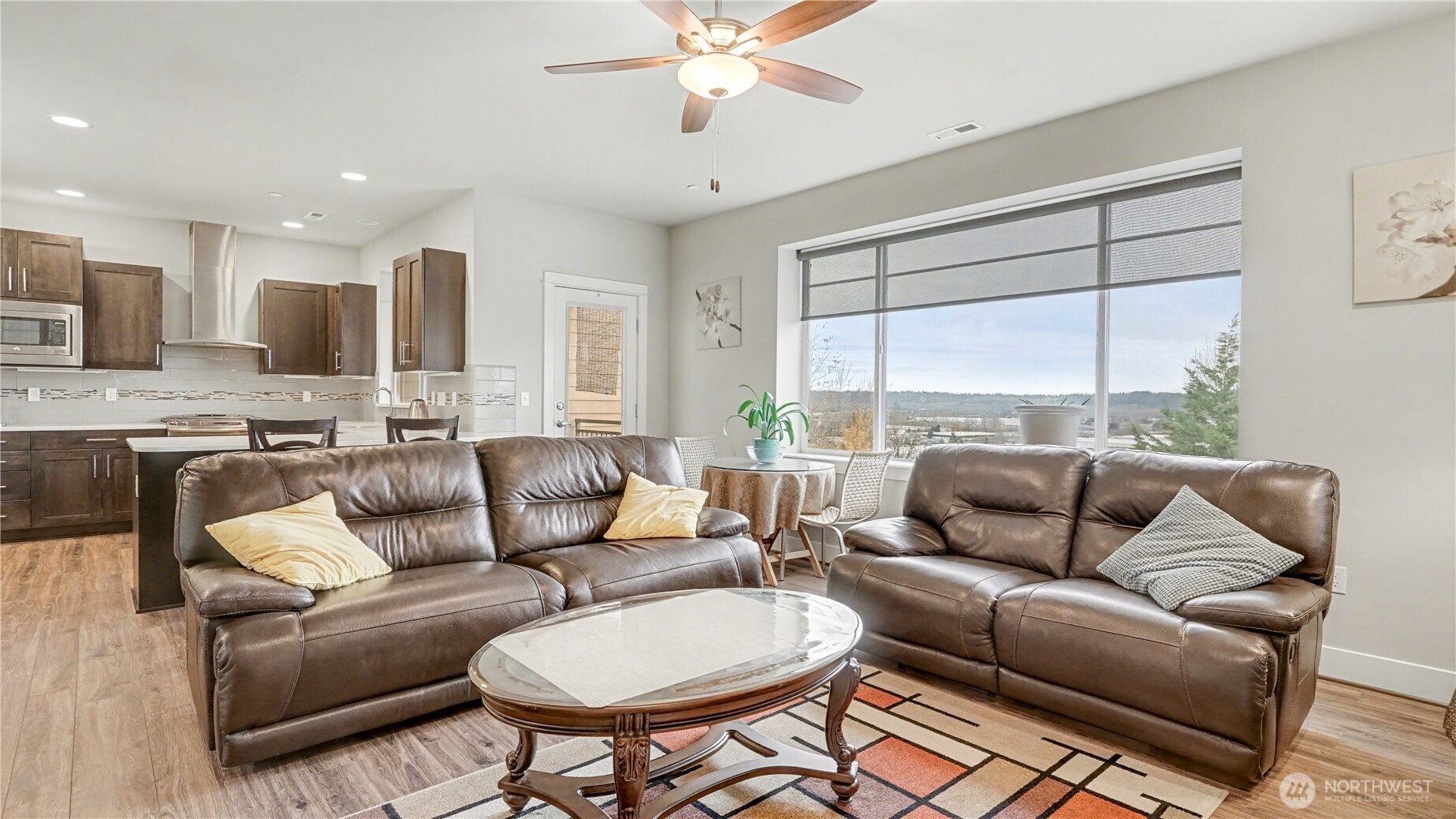 Living room is filled with natural light from large windows and offers seamless access to your private patio.