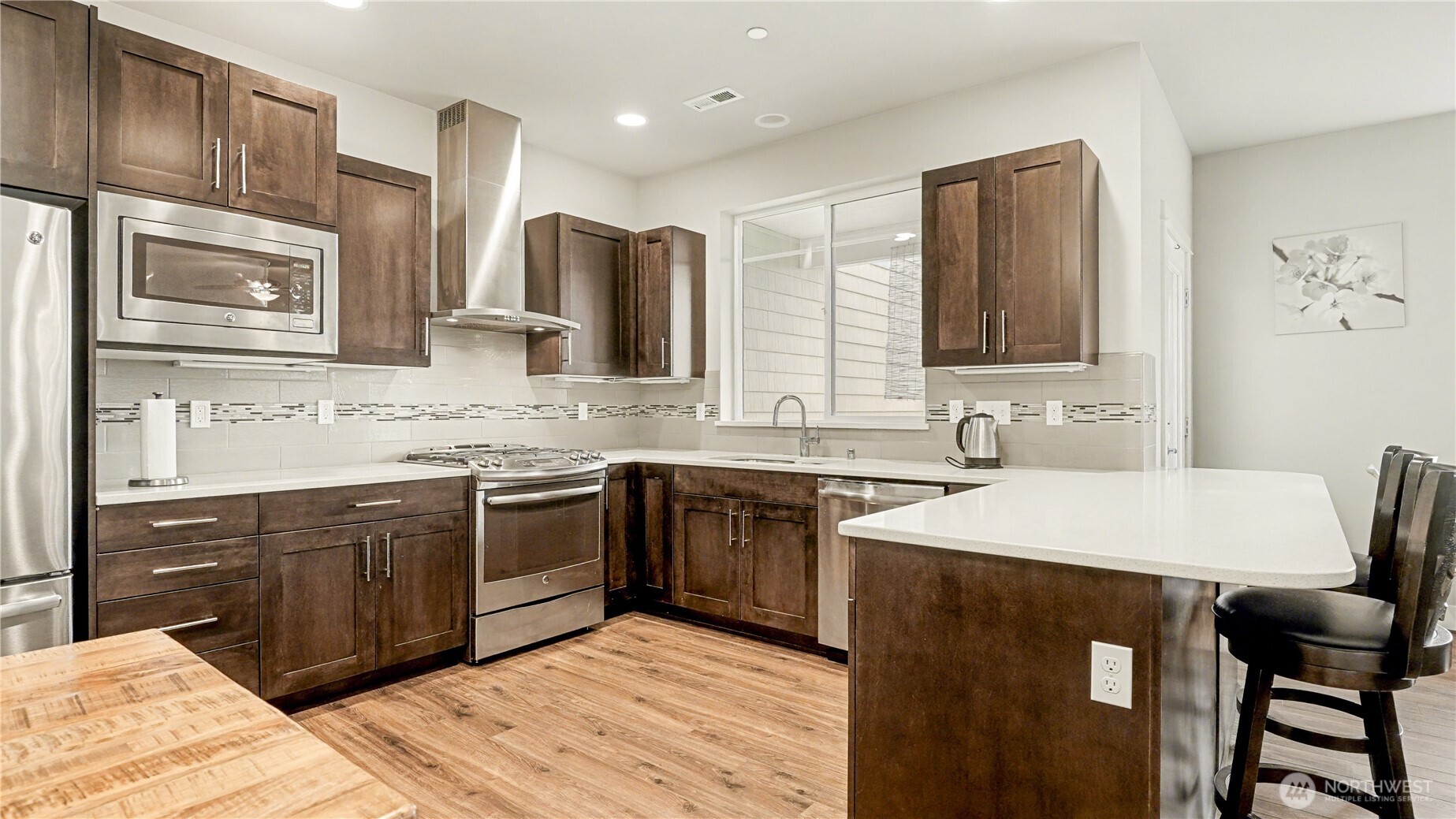 Kitchen offers stainless steel appliances, rich dark cabinetry, and granite countertops.