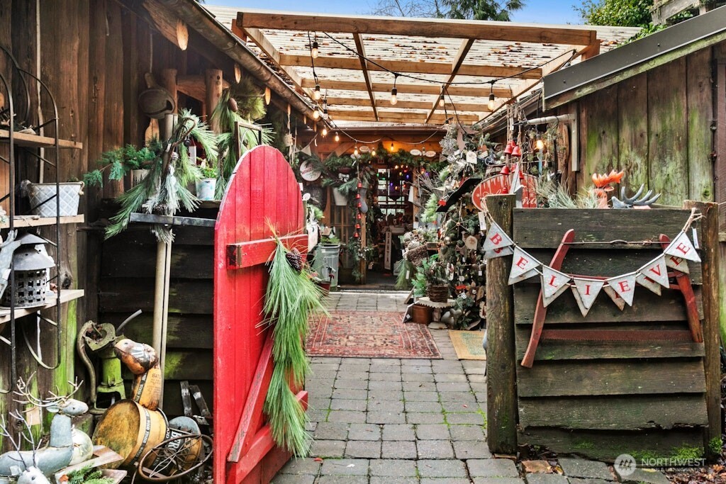 Walkway between log home and the original stable and home to left and additional building in distance. All being used as part of Timber Creek active business.